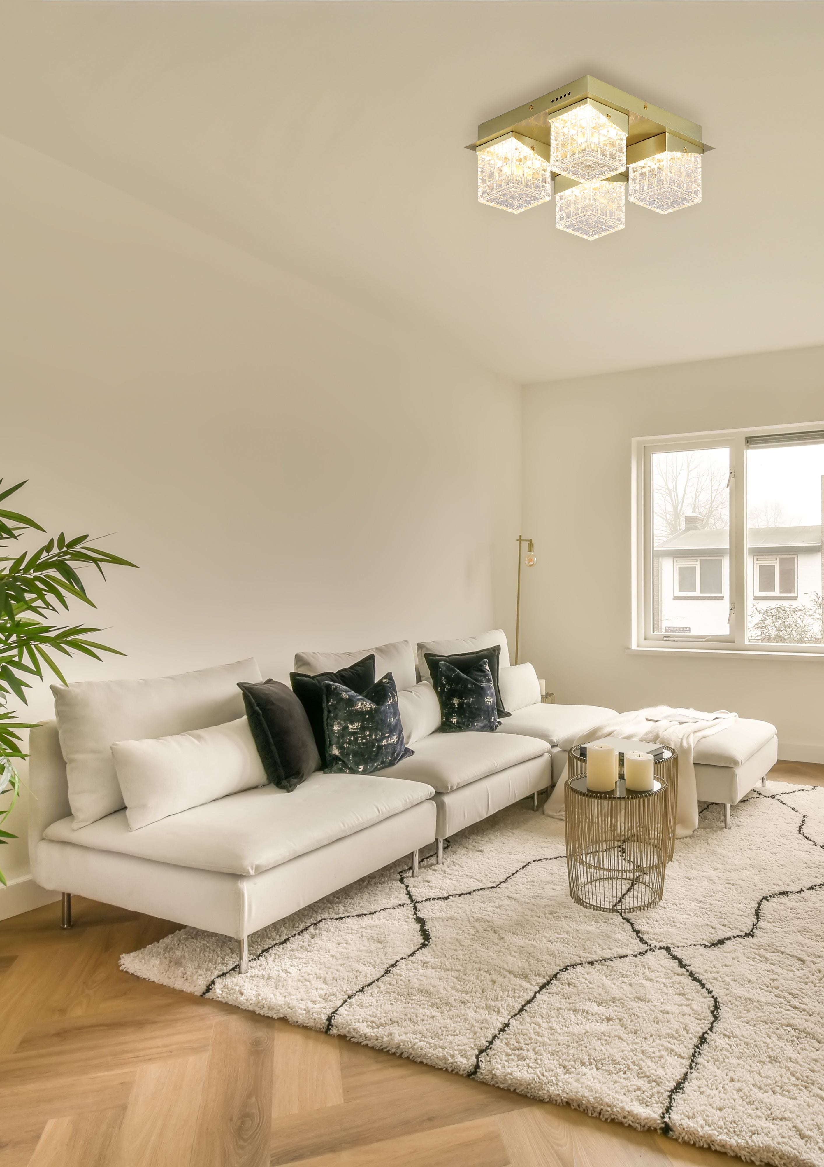 Cuboid 4 Light Flush fitted to the ceiling of a cream living room with a white sofa and dark cushions