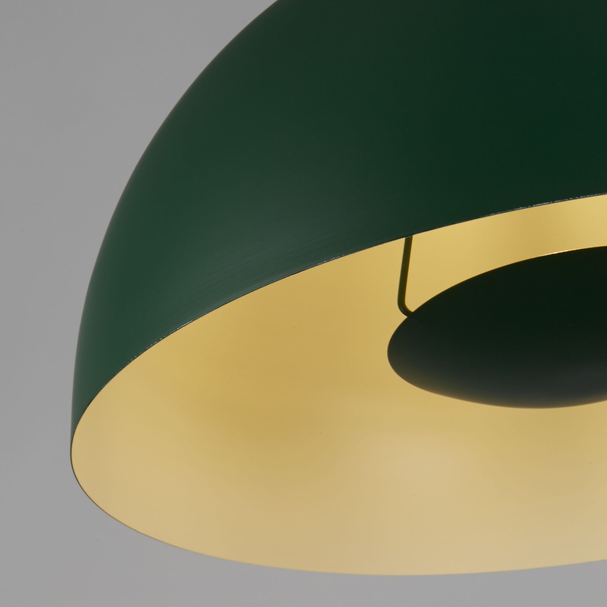 Close up of the Mars pendant's rim, showing the matt green exterior meeting the gold interior of the dome shade with the lamp holder just visible