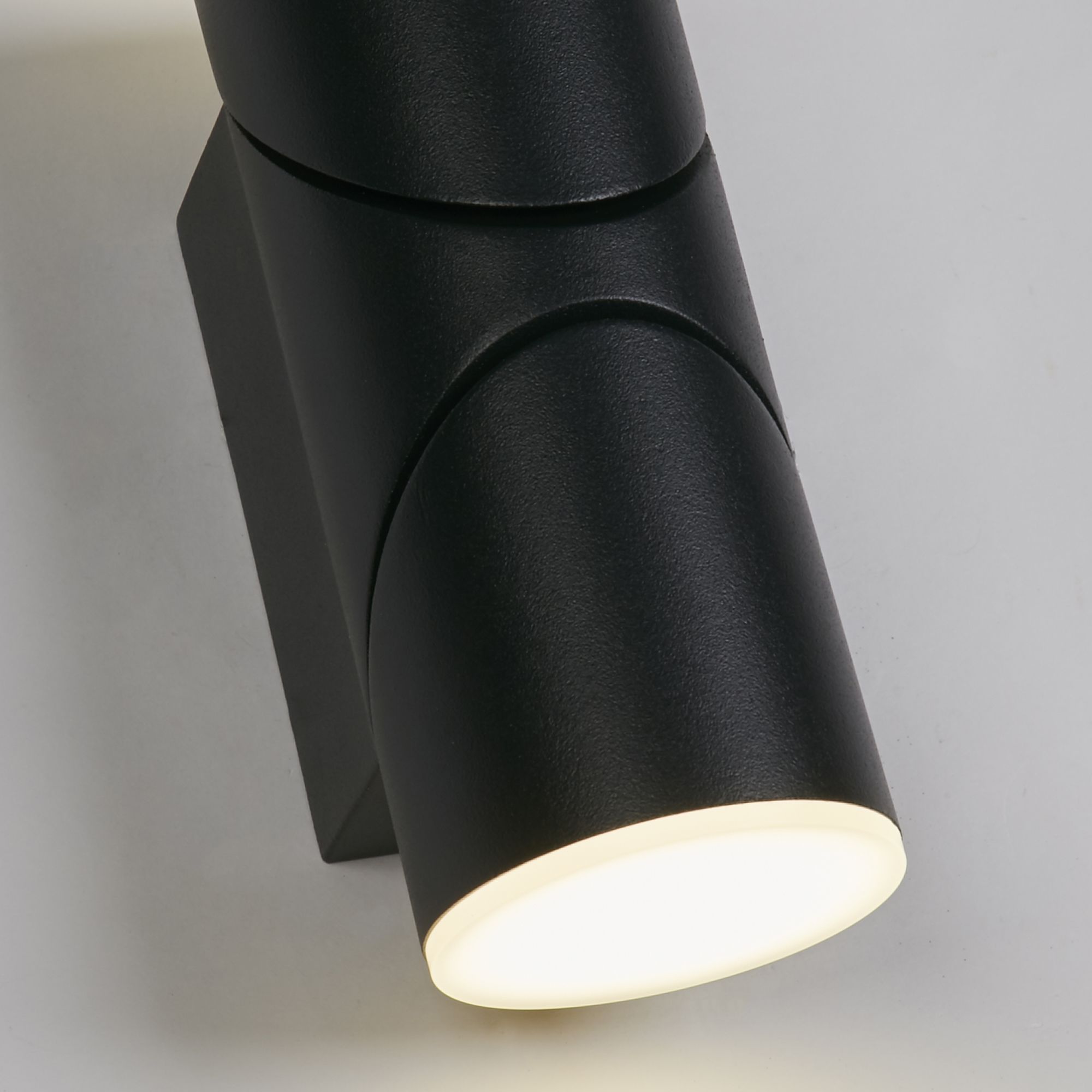 Close up of the Soho wall light's adjustable head tilted to direct light downward