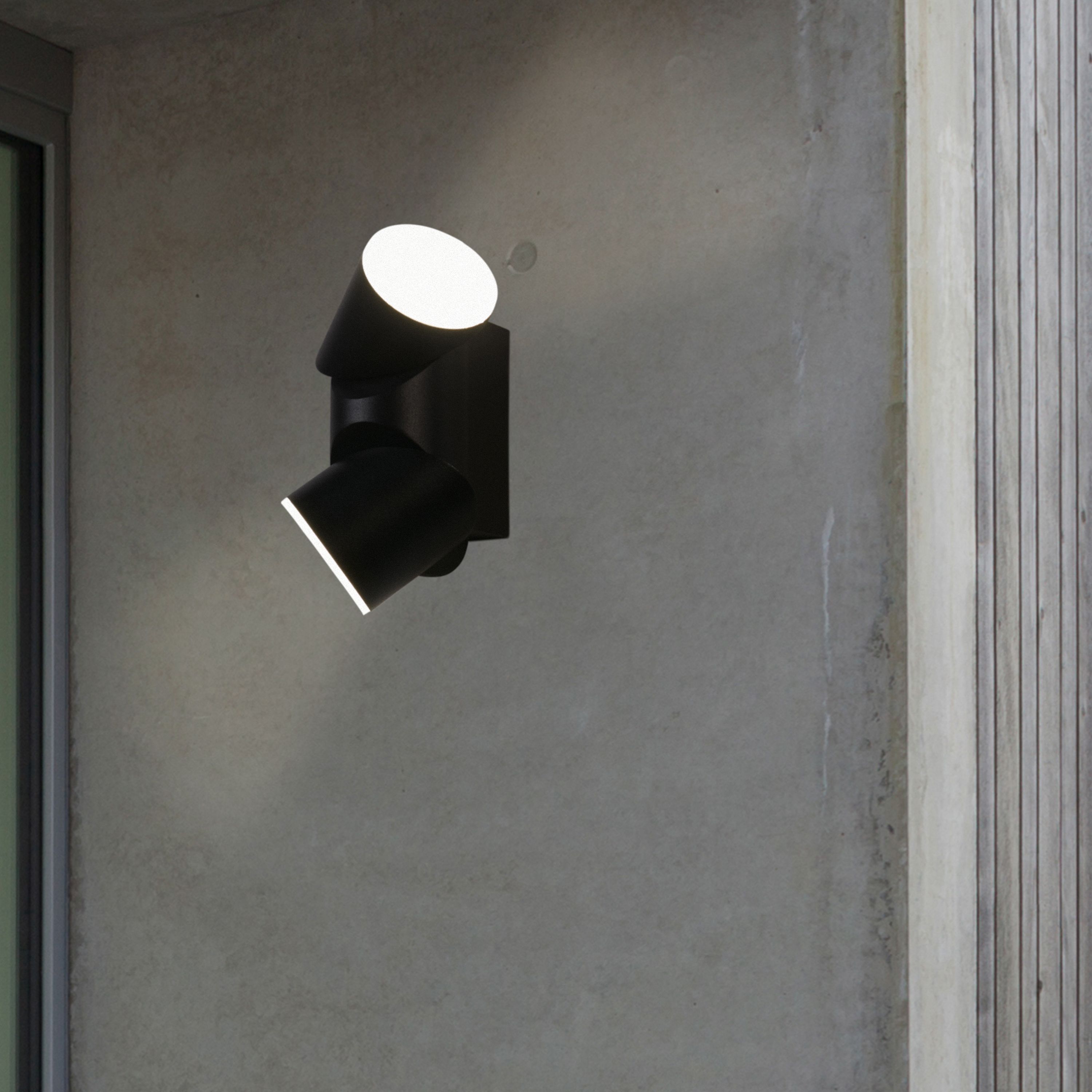 Soho black outdoor wall light mounted beside a doorway with both heads angled to cast light down the wall