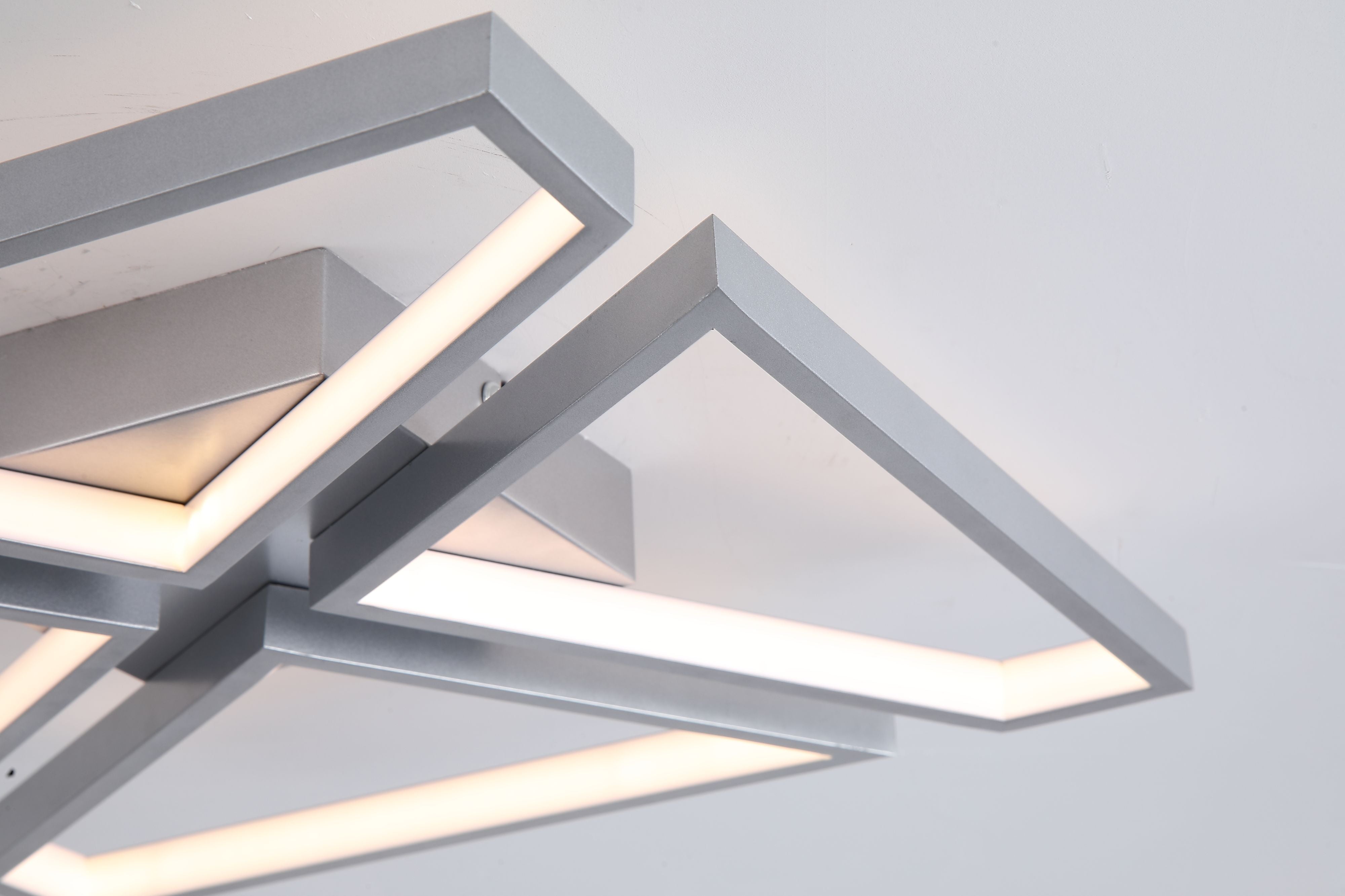 Close up detail of the Searchlight Quatro LED Flush ceiling light showing the aluminium frame edges and white polycarbonate diffuser glowing warm white