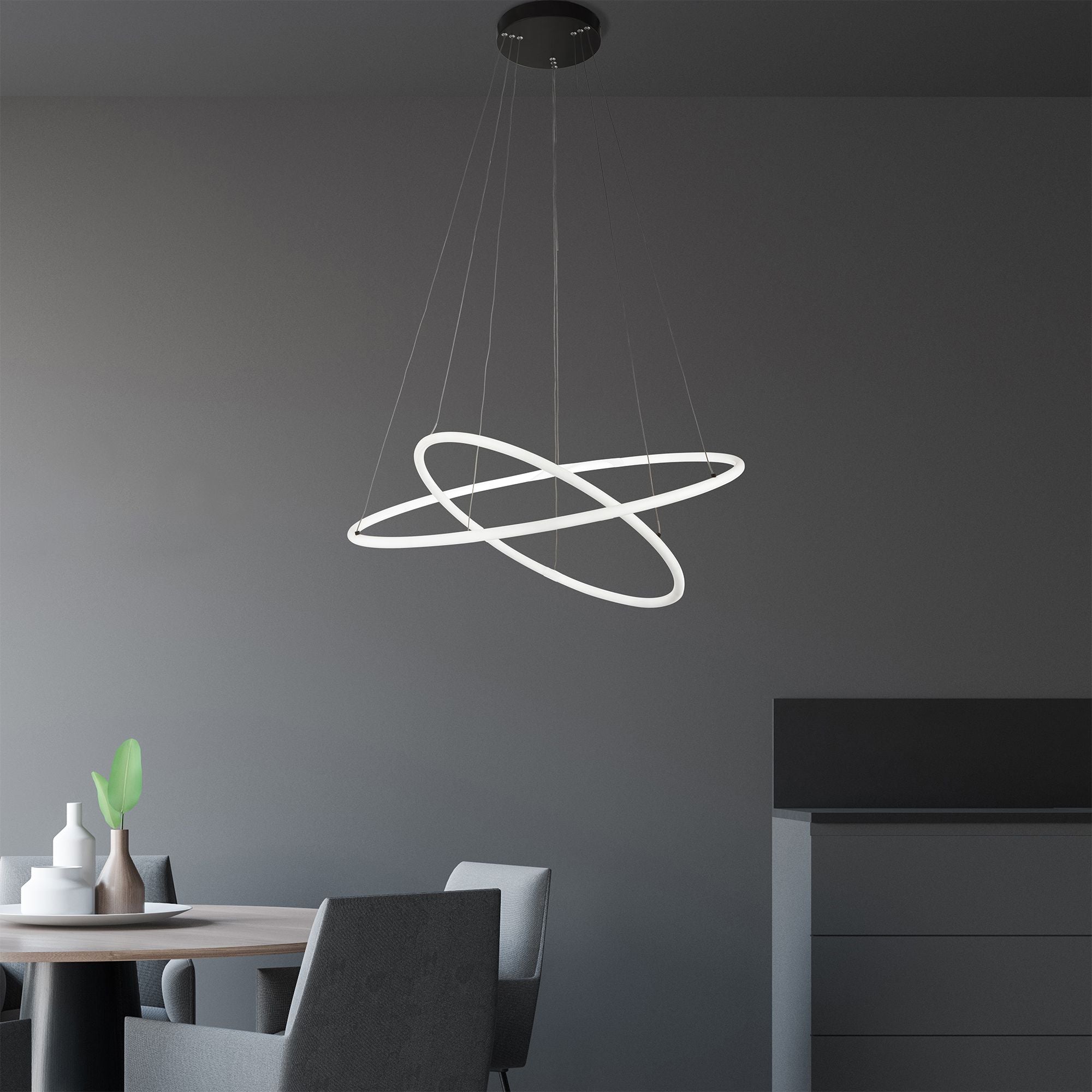 Searchlight Revolve 2 light ring pendant styled at an angle over a dining table, with dining chairs and a vase of foliage below