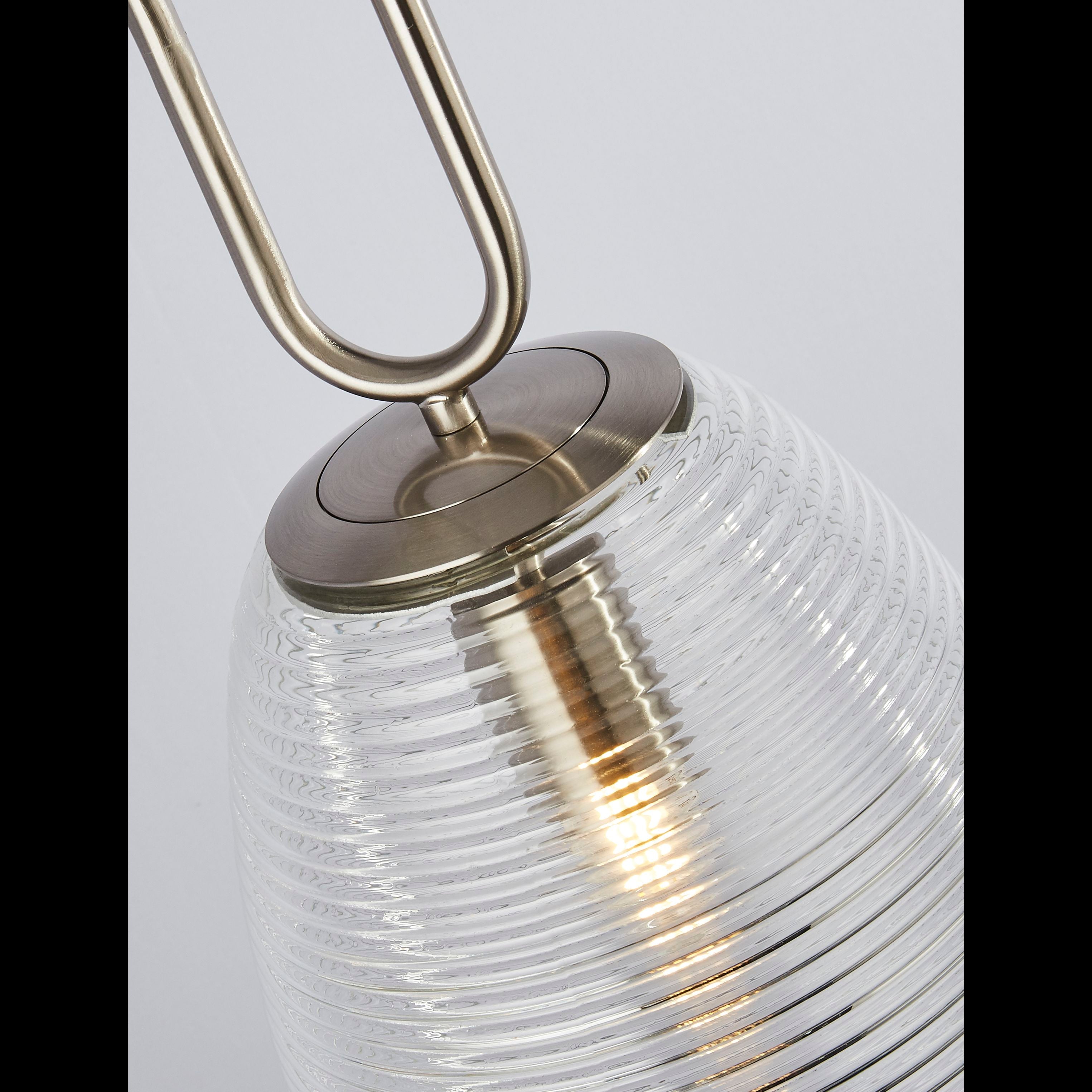 Close up of the satin nickel oval link and ribbed glass shade on the Searchlight Elixir pendant, showing the lit bulb inside