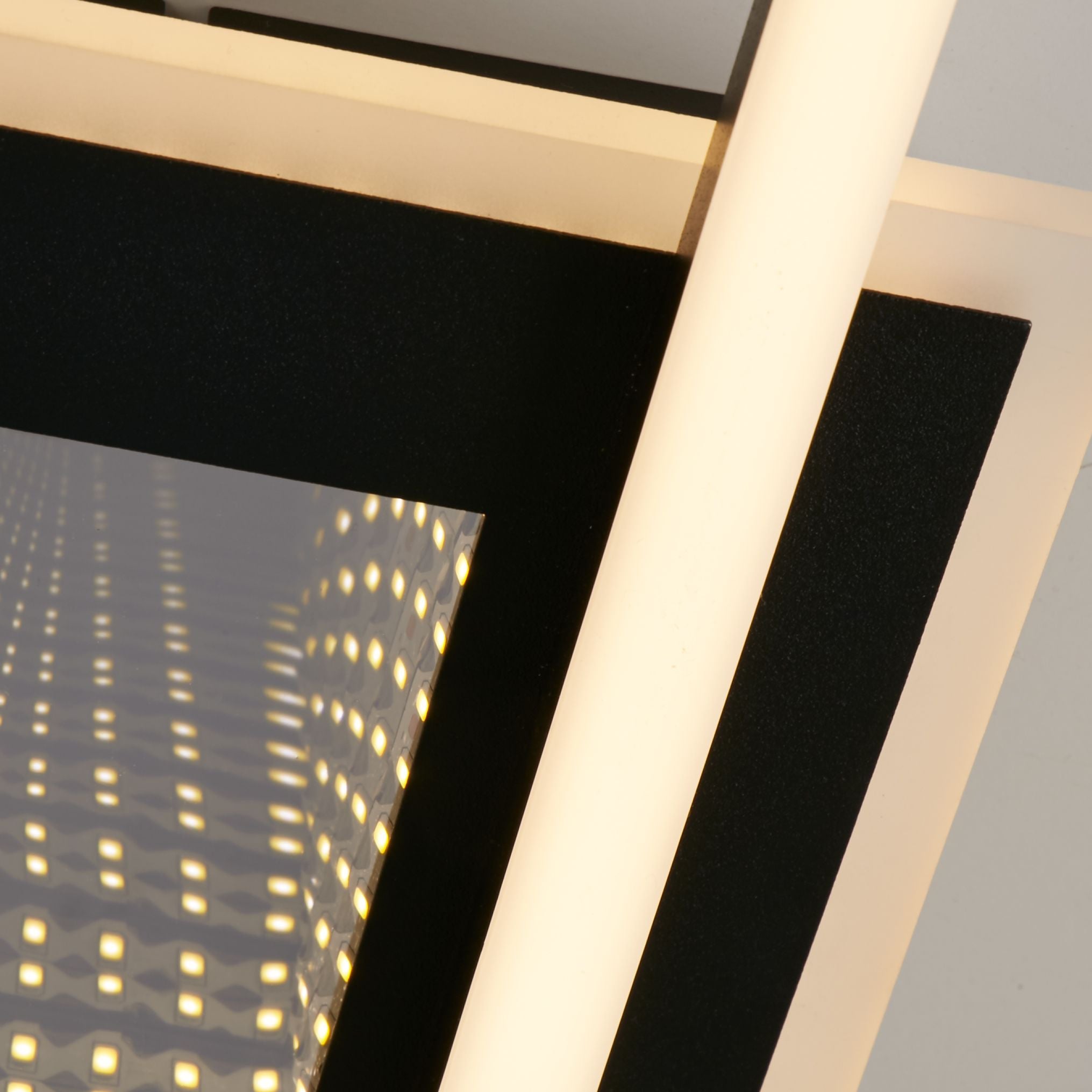 Close up detail of the Searchlight Quadrate LED Flush ceiling light showing the black frame edge and the textured dimpled panel glowing warm white