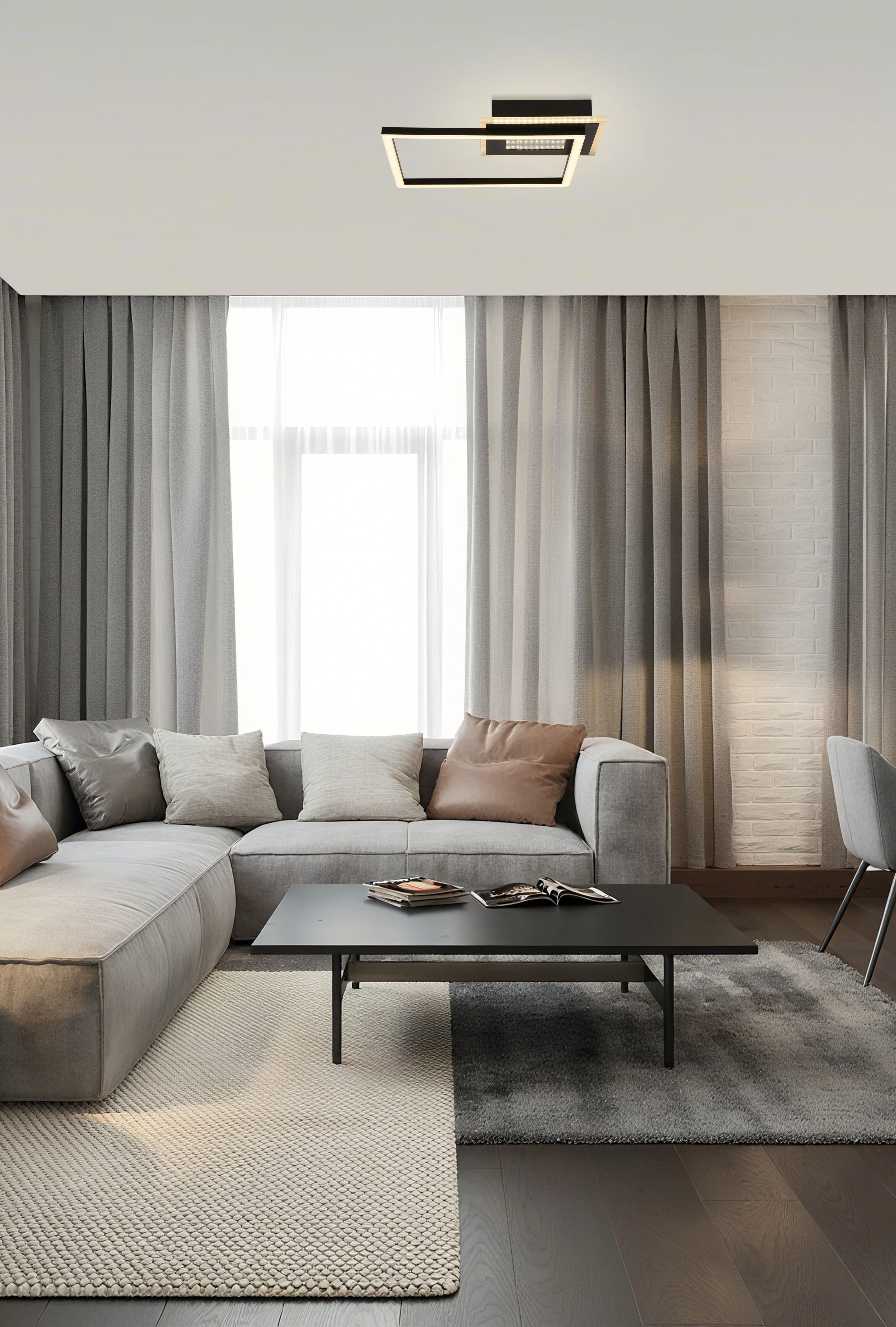 Searchlight Quadrate LED Flush ceiling light in matt black, styled above a grey sofa and dark coffee table in front of curtained windows in a modern living room