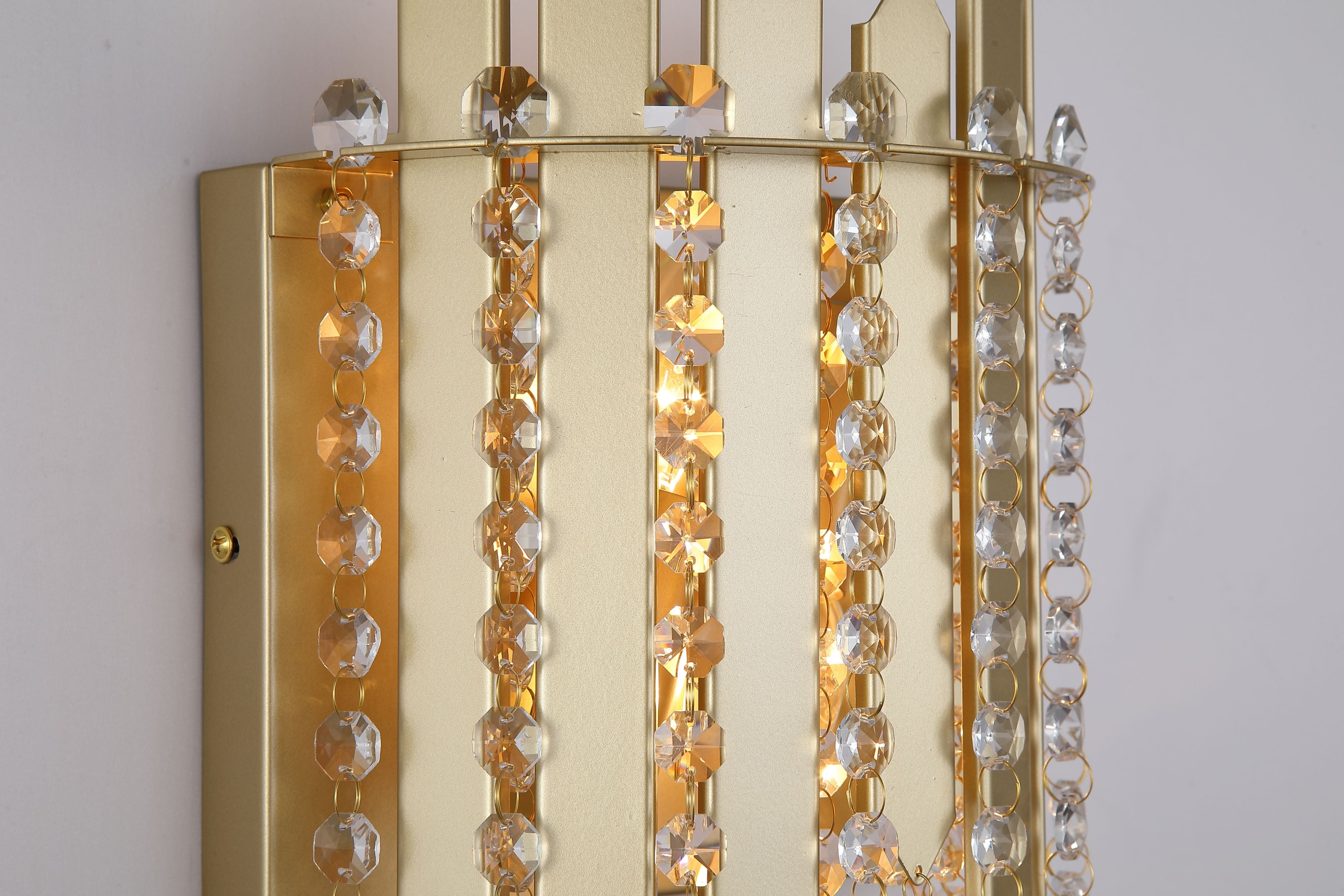 Close up of the Searchlight Spear 2 Light Wall Light showing the gold metal panel texture and faceted crystal octagon beads, with the wall mounting plate visible