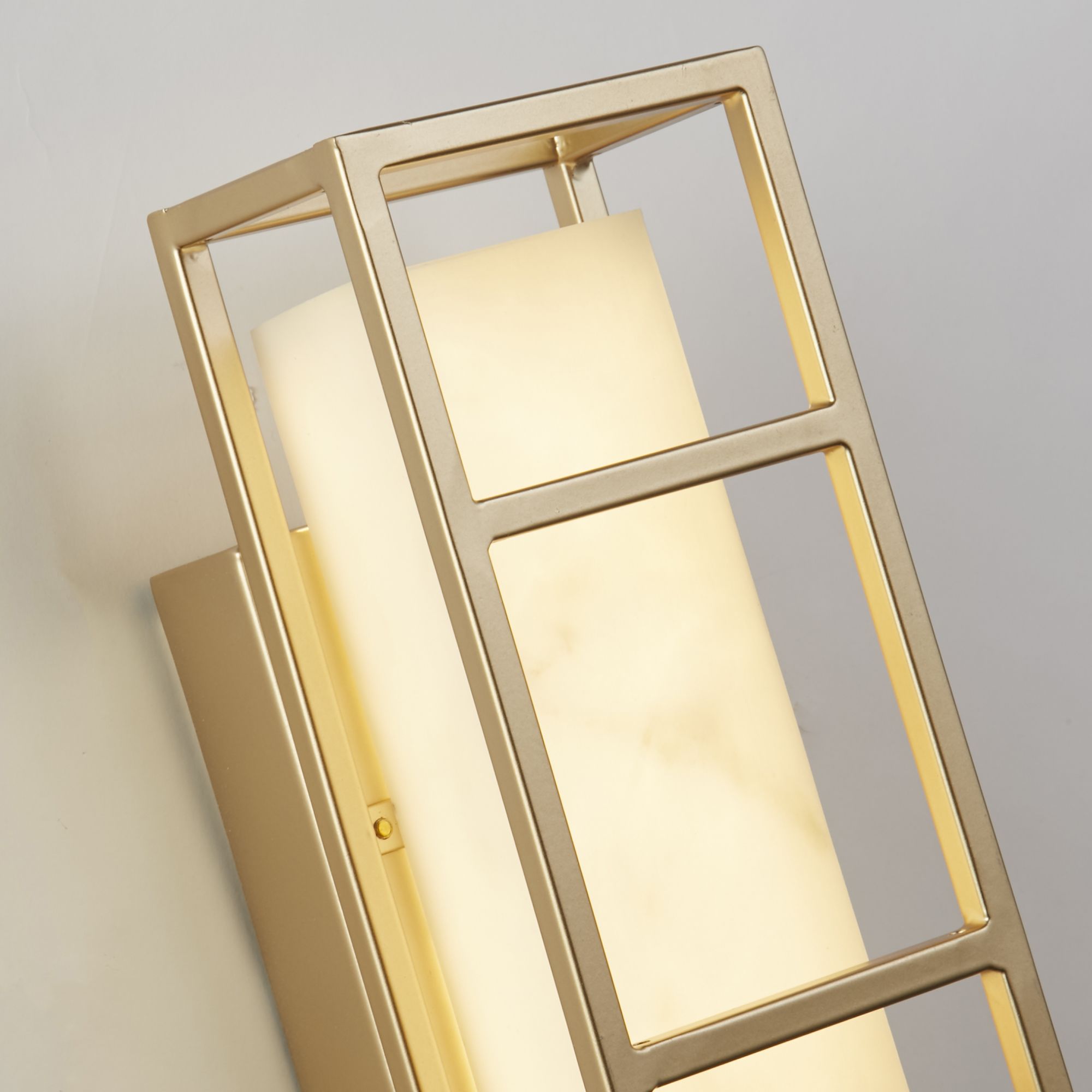 Close up of the matt gold frame joint and marble effect resin texture on the Searchlight Mirage LED wall light