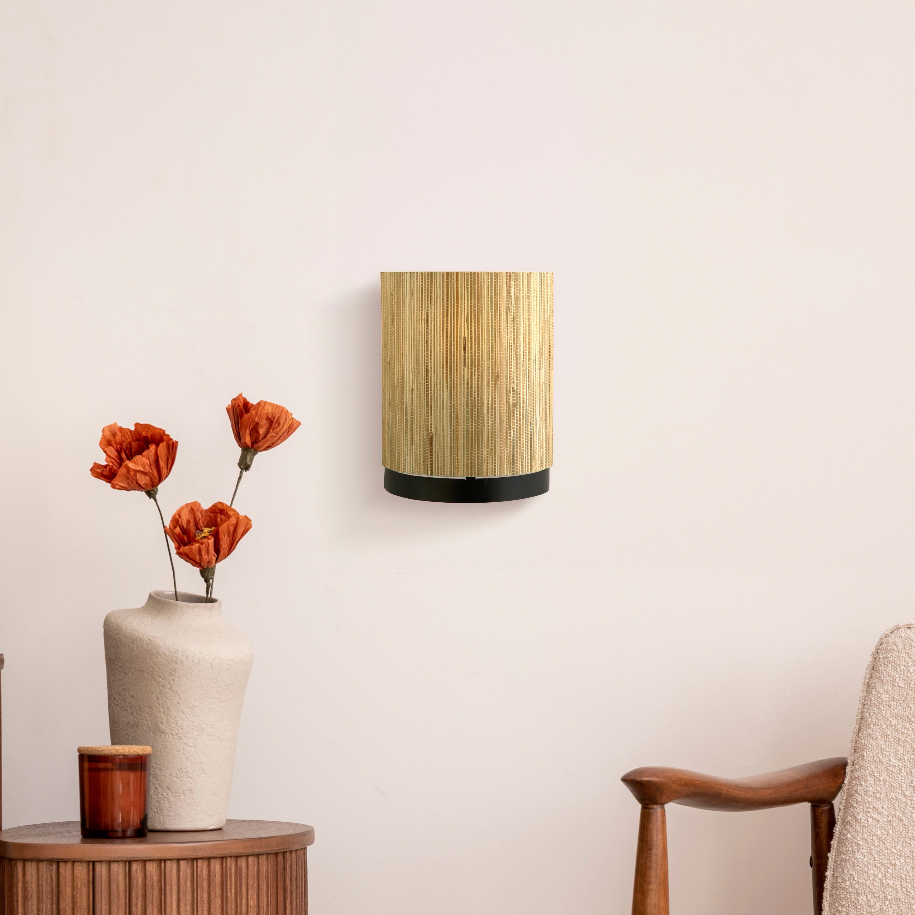 Searchlight Meadow wall light mounted on a pale wall beside a ceramic vase with dried poppies