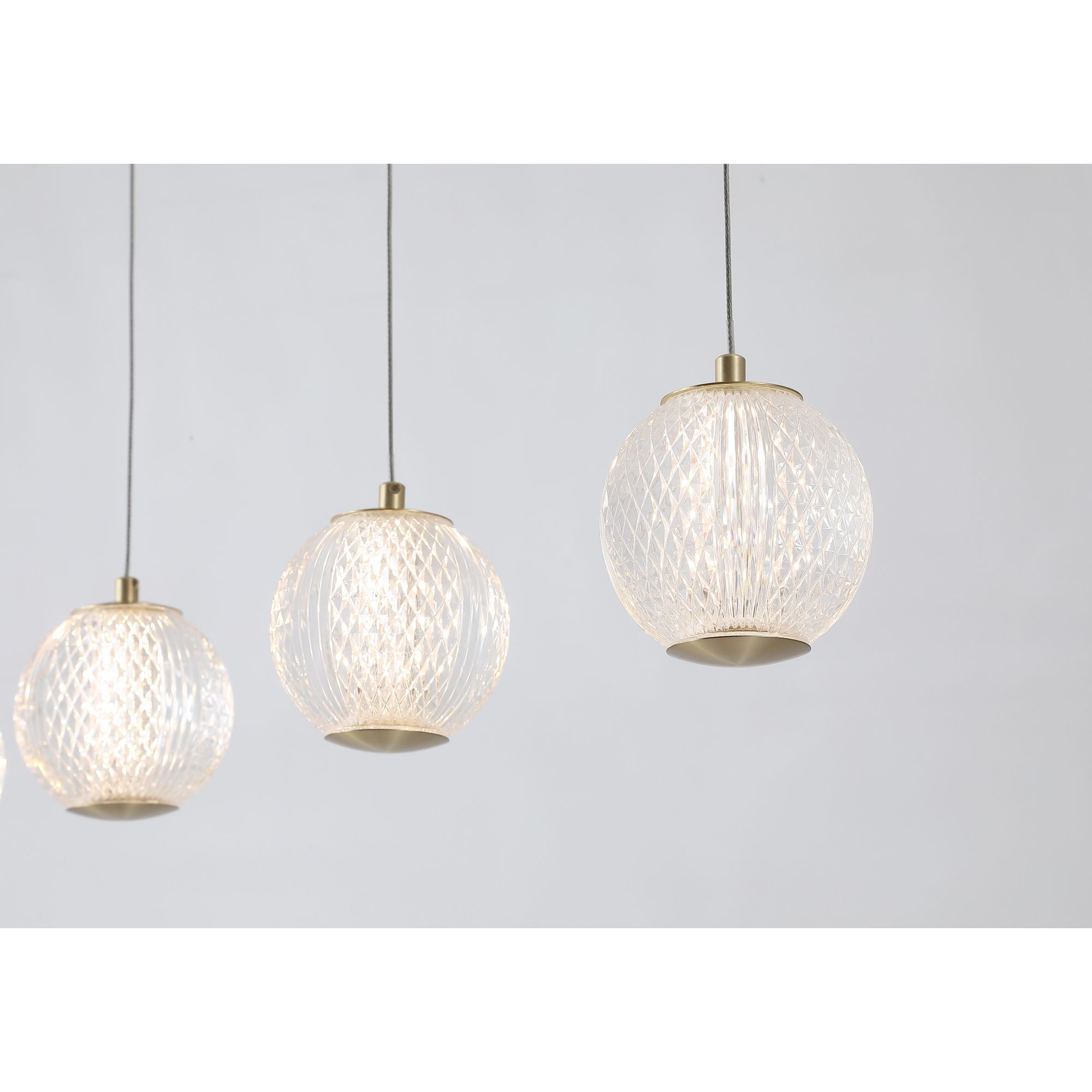 Close up of three etched acrylic globes on the Allure bar pendant, showing the diamond cut texture lit from within