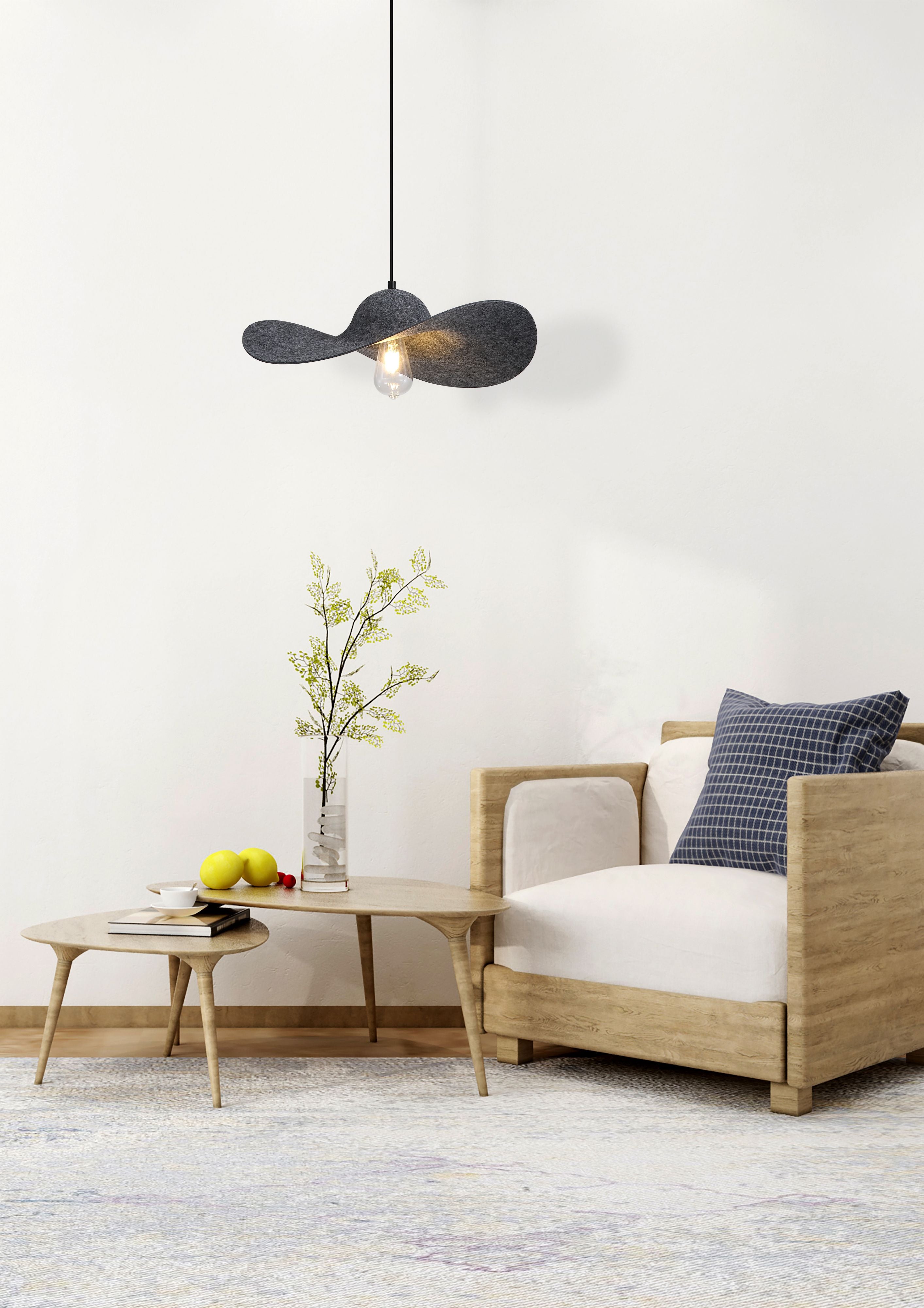 Ripple pendant light styled above a coffee table beside a beige armchair in a bright living room