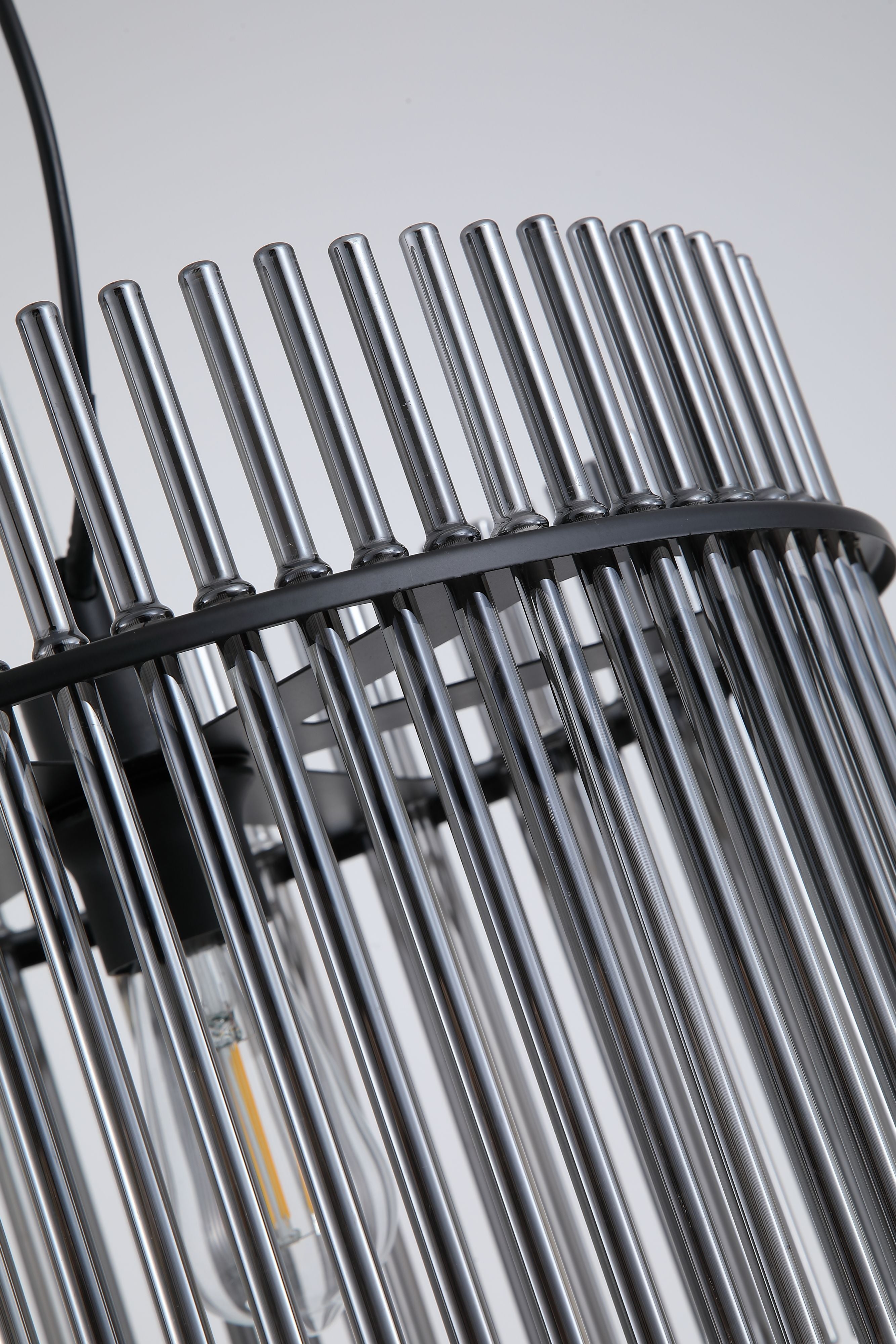 Close up of the Swizzle 40cm pendant shade, densely arranged smoked glass rods around the lit E27 bulb and black mounting ring