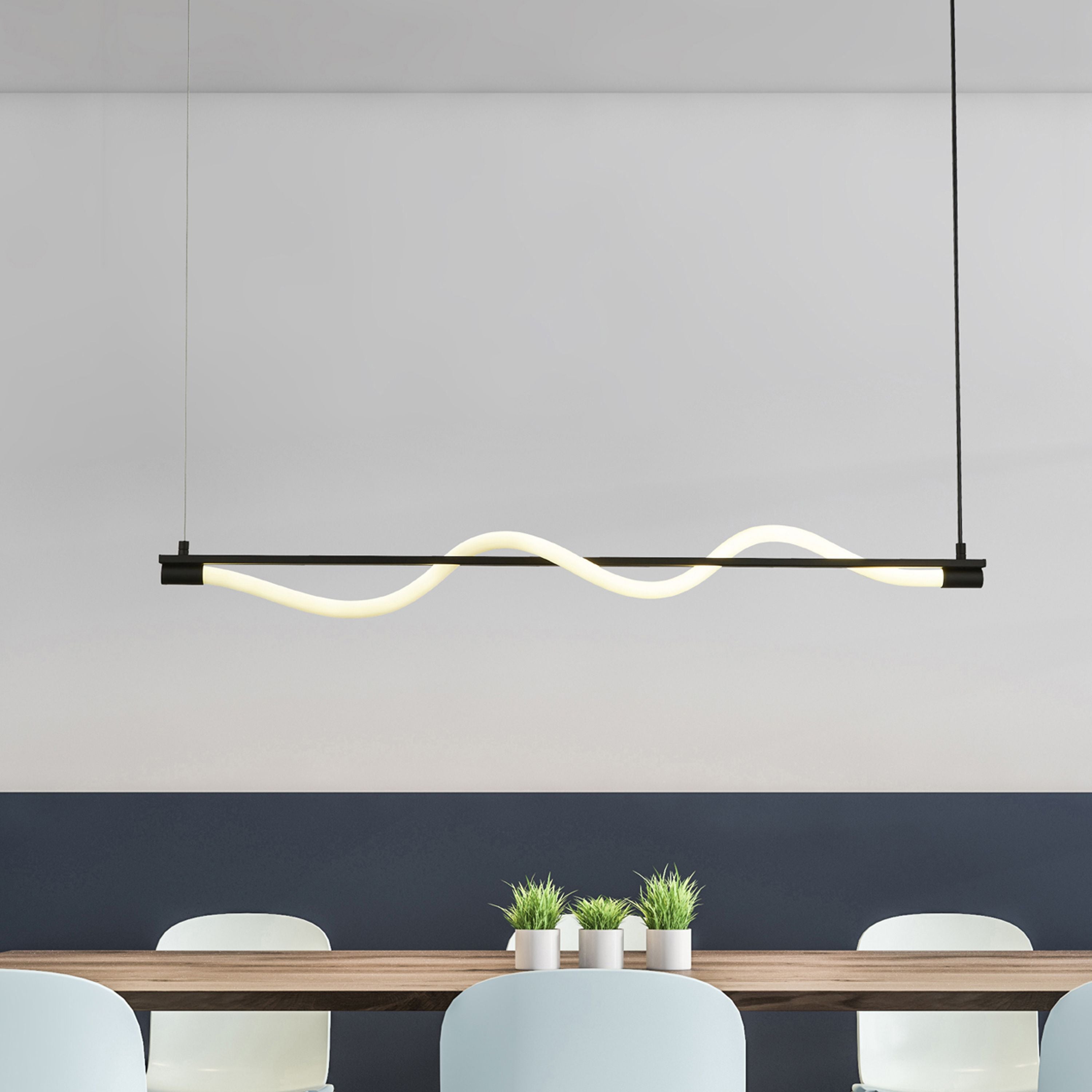 Serpent Pendant in black with opal tube styled above a wooden dining table with potted plants and a navy accent wall