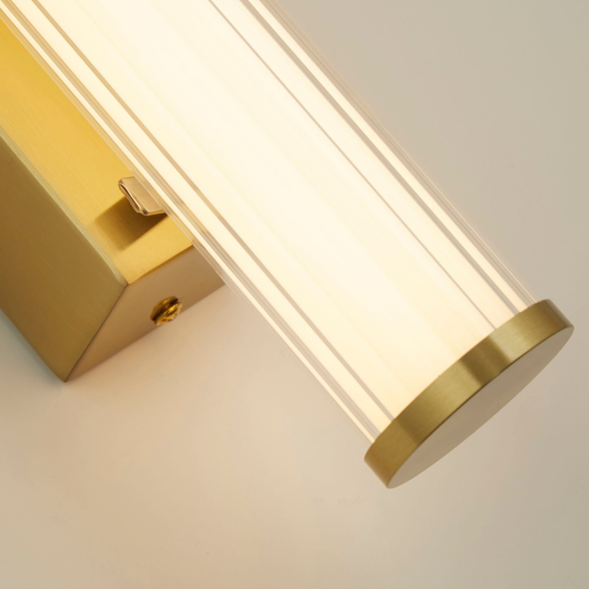 Close up of the gold clamp bracket and mounting screw on the Searchlight Clamp wall light, ribbed glass lit