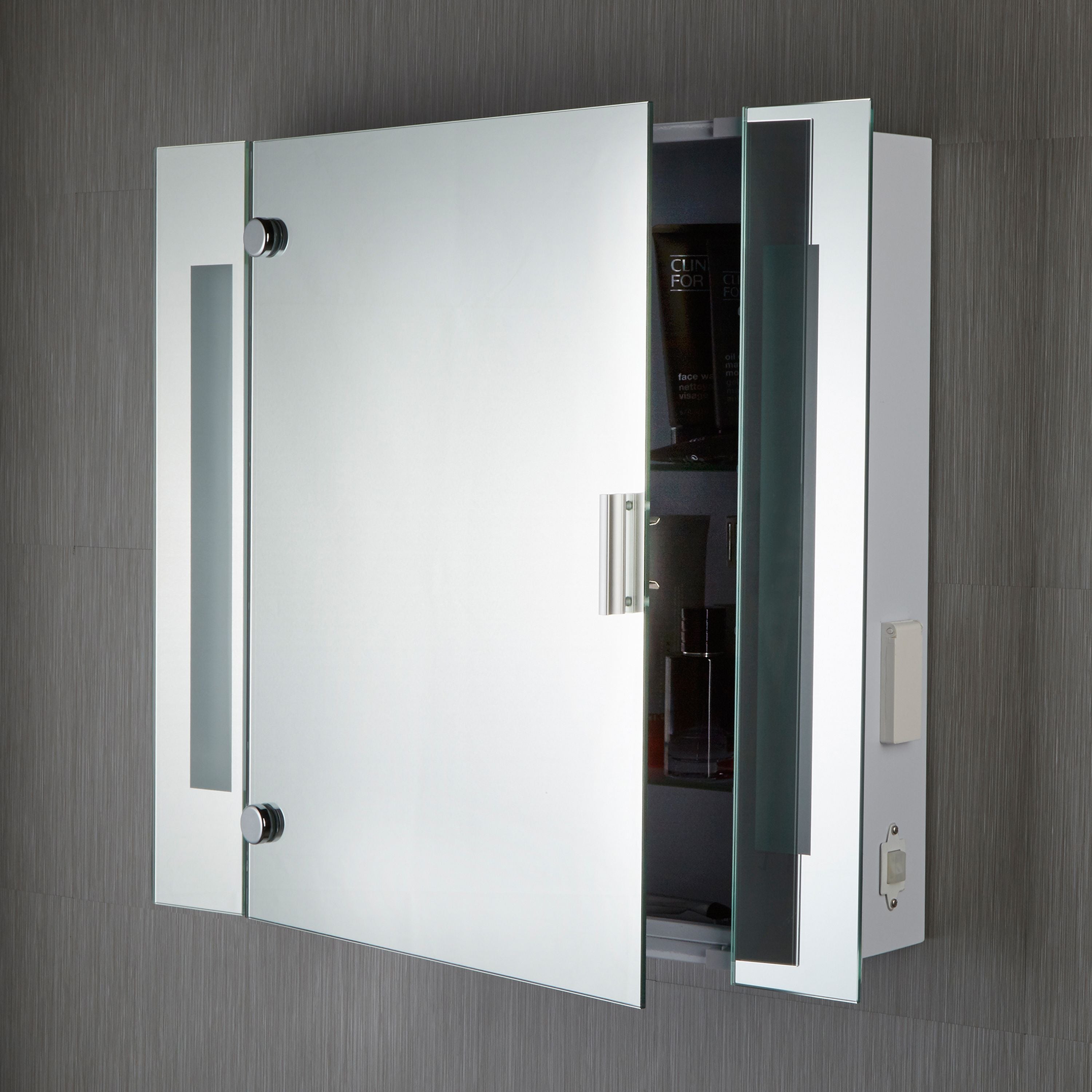 Searchlight mirror cabinet wall mounted with the door open, showing the shaver socket and switch on the side panel and toiletries on the interior shelf