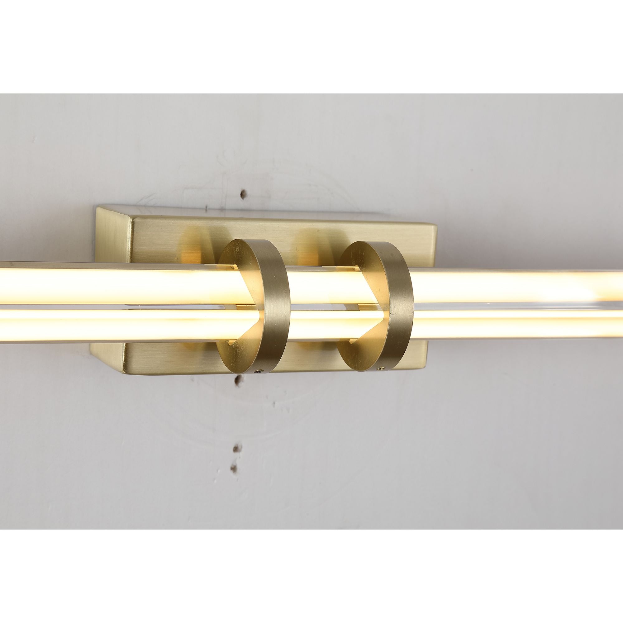 Close up of the Parma's satin brass centre bracket and clear ribbed glass tube, showing the integrated LED strip