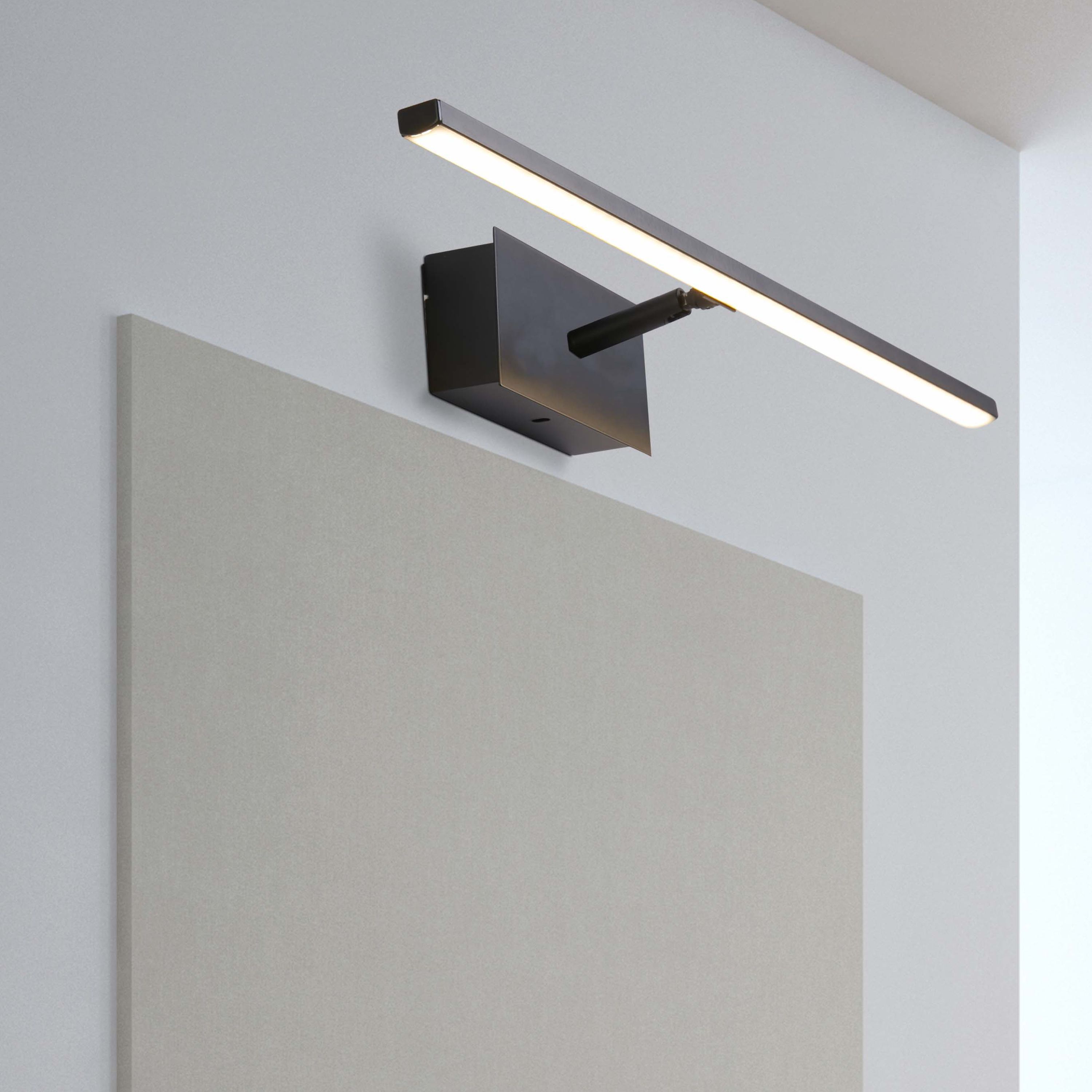 Amalfi 41cm LED wall light in matt black installed above a bathroom mirror, illuminated with a warm white glow