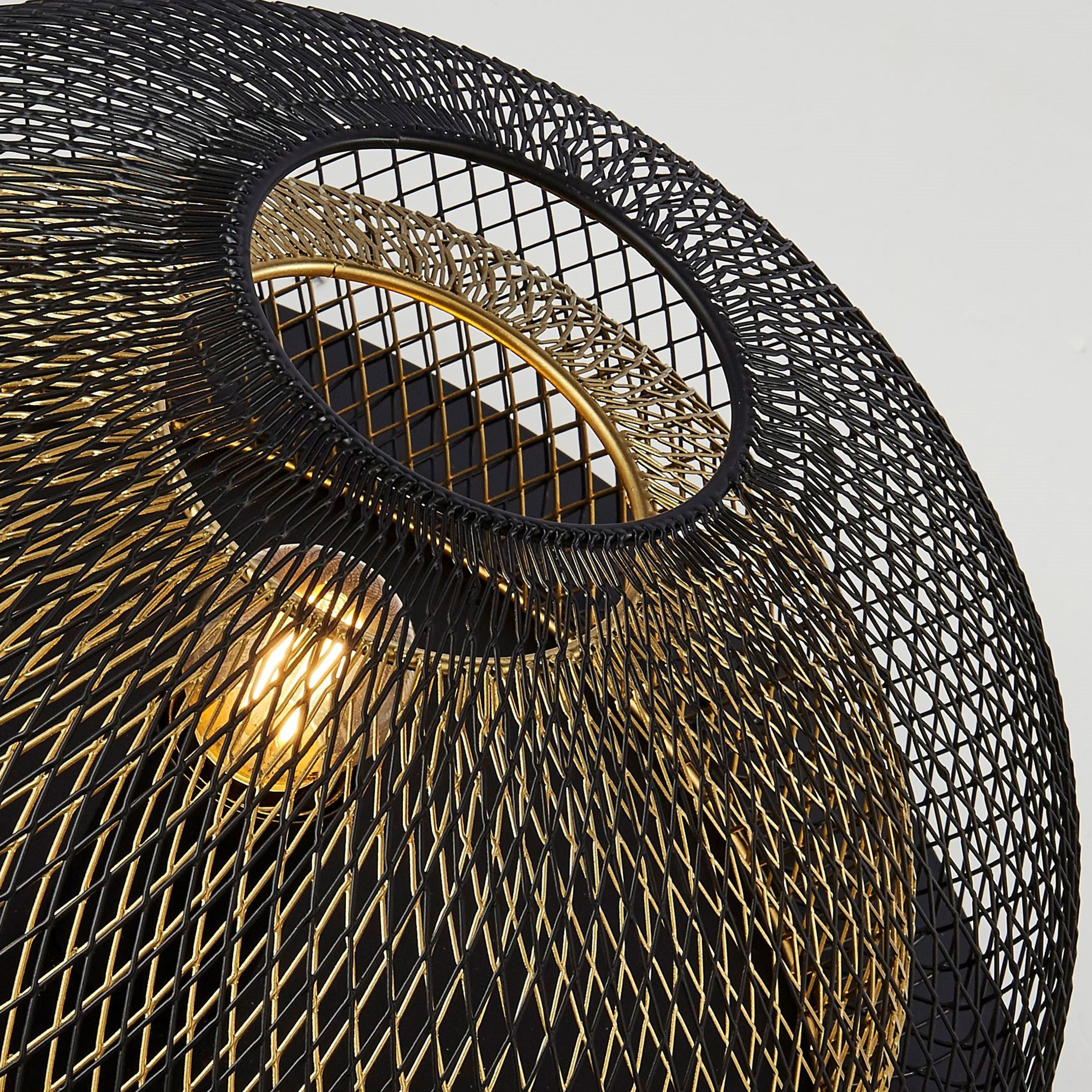 Close up of the Honeycomb flush light's centre opening, showing the gold inner mesh ring and lit bulb through the black outer mesh