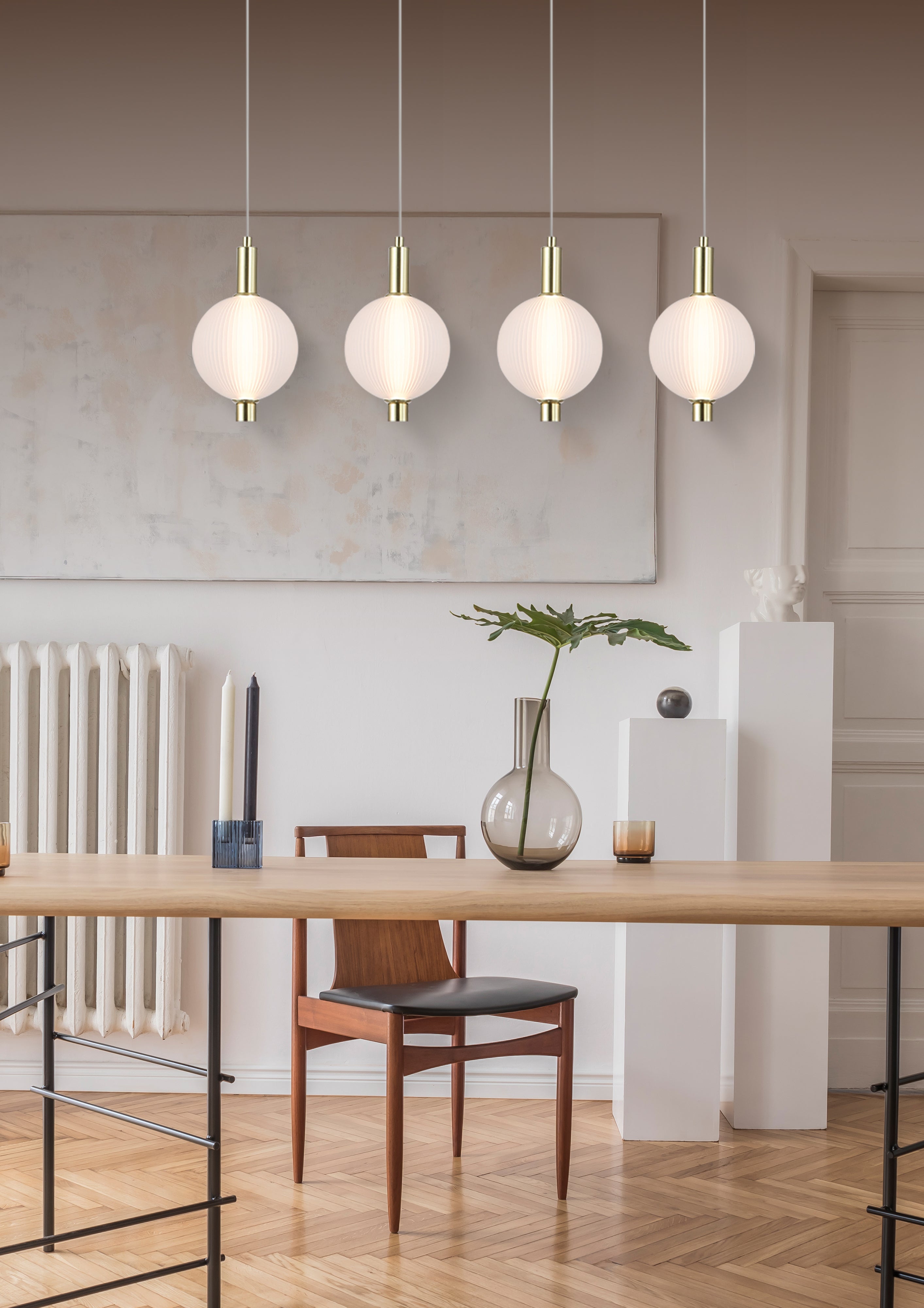 Searchlight Luminique LED 4 light bar pendant in satin brass, lit above a wooden dining table with a mid century chair