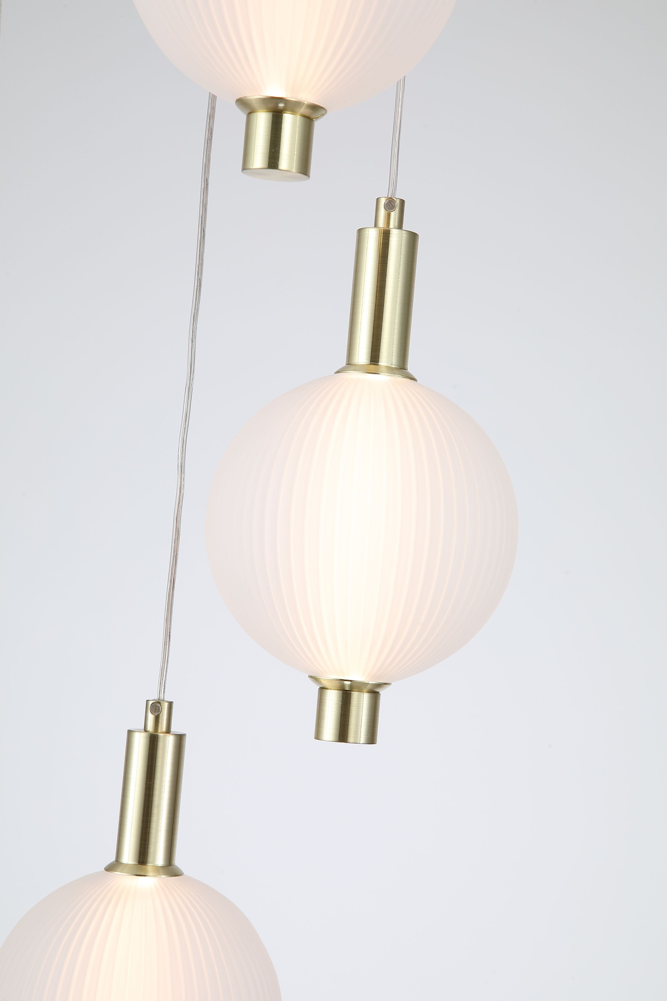 Searchlight Luminique LED 5 light pendant in satin brass, close up of the ribbed opal glass globes and satin brass fittings