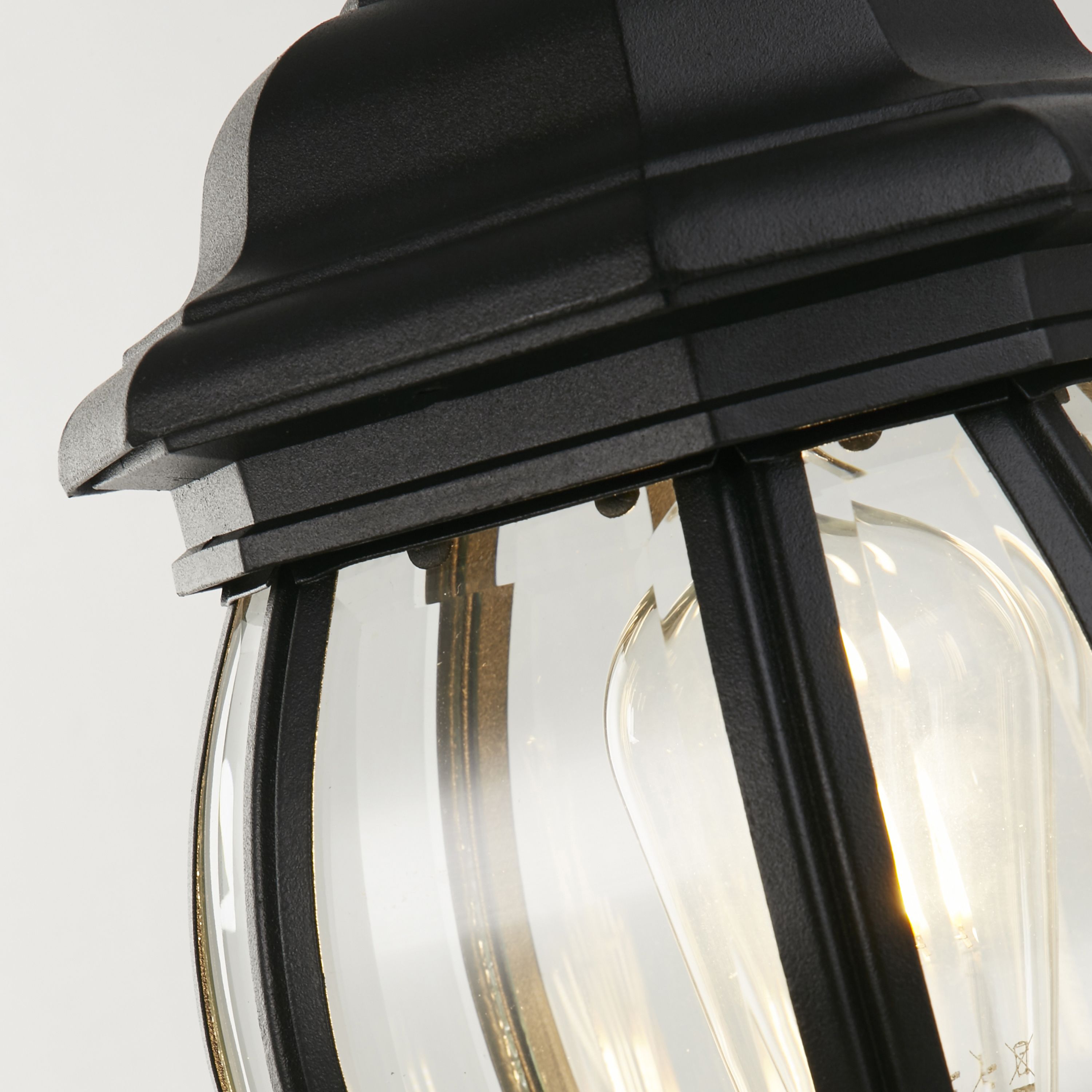 Close up of the Bel Aire Outdoor Post's lantern head, showing the faceted clear glass and black frame detail around the bulb