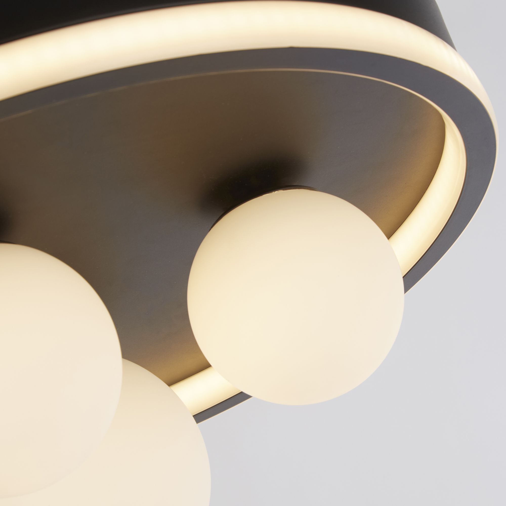 Close up detail of the Trident's lit ring edge and opal glass globes against the black backplate
