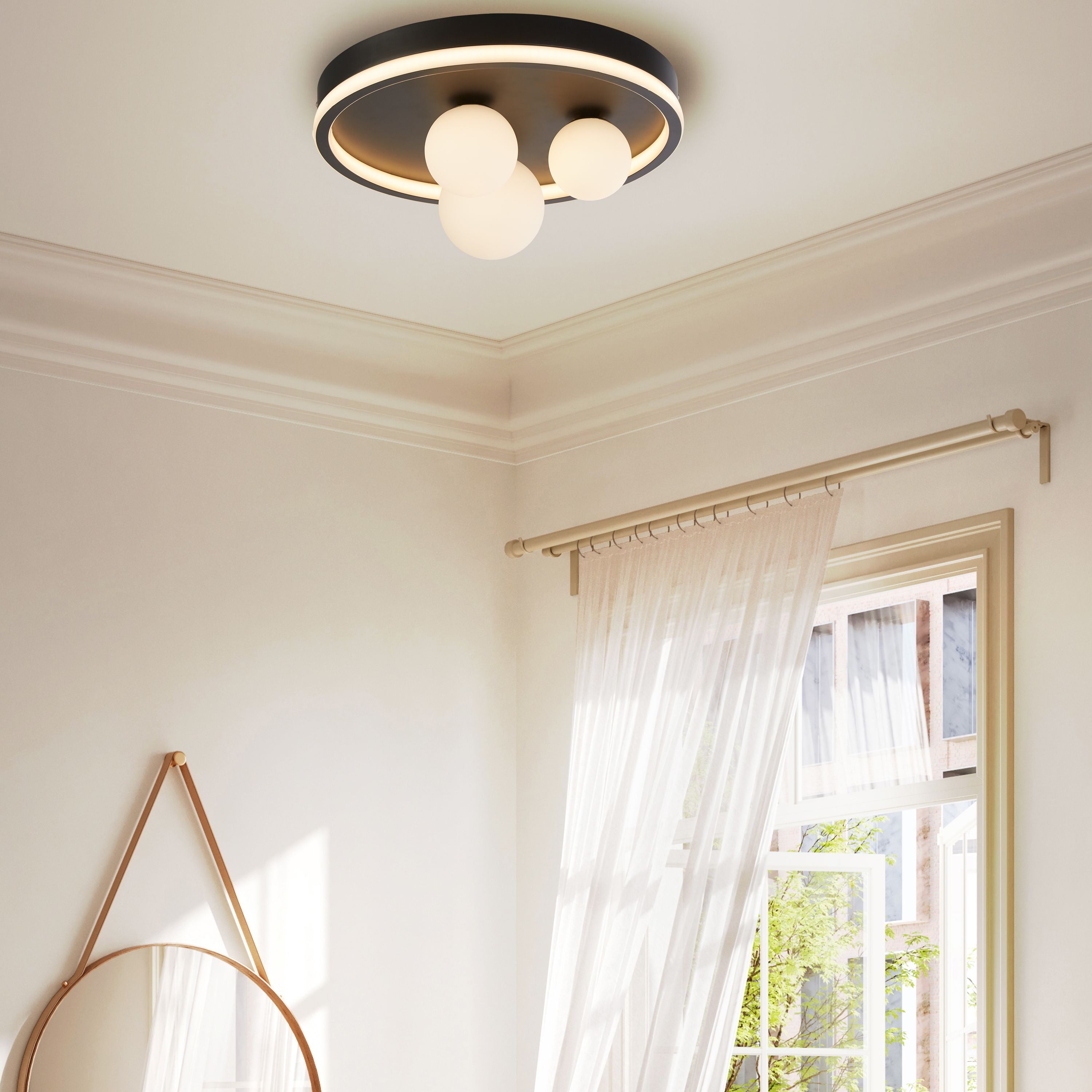 Trident LED flush ceiling light in black installed in a bedroom with sheer curtains and a round mirror