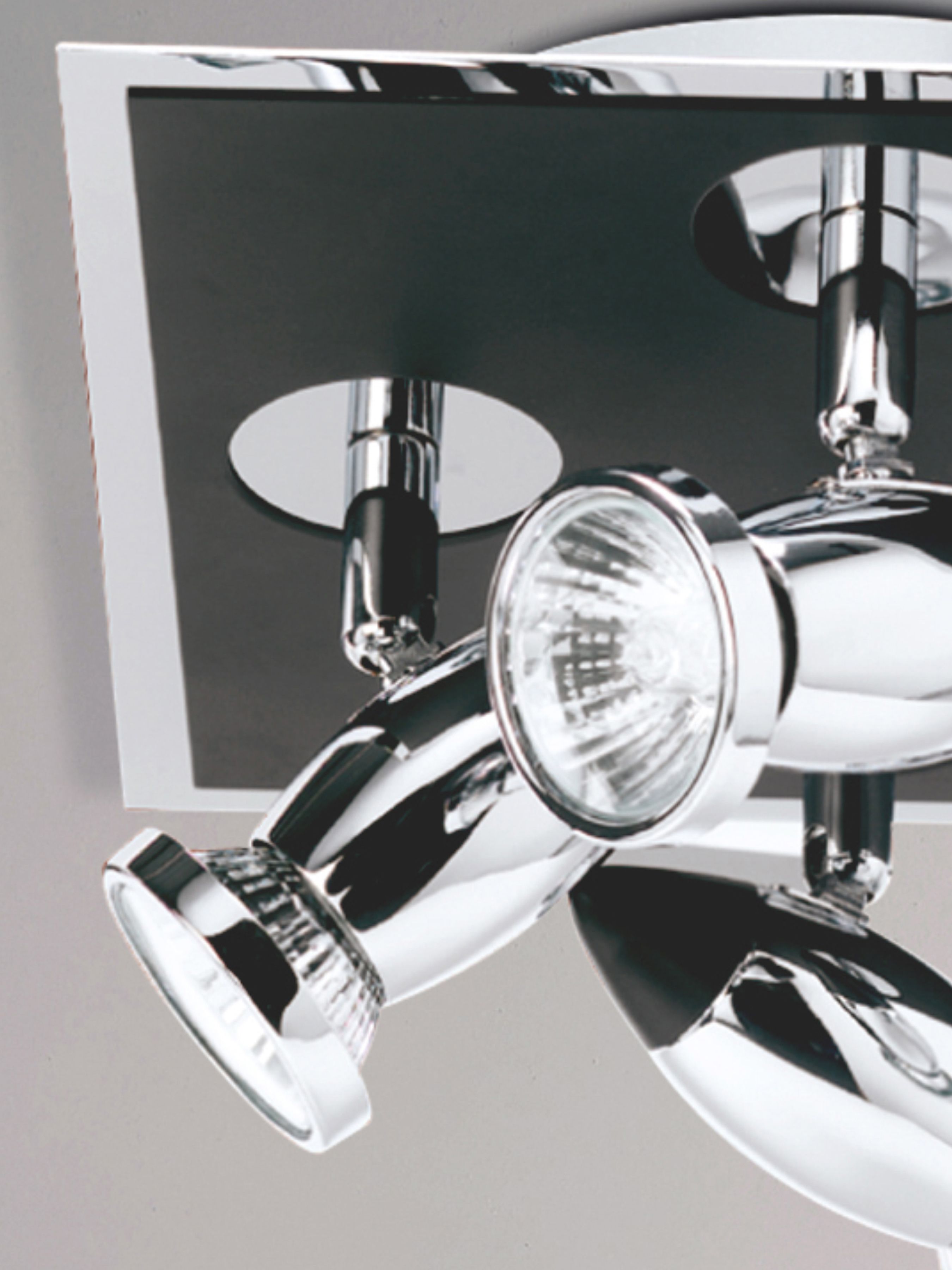 Close up of one polished chrome spotlight head on the Comet 4 light fitting, showing the halogen style bulb against the matt black backplate