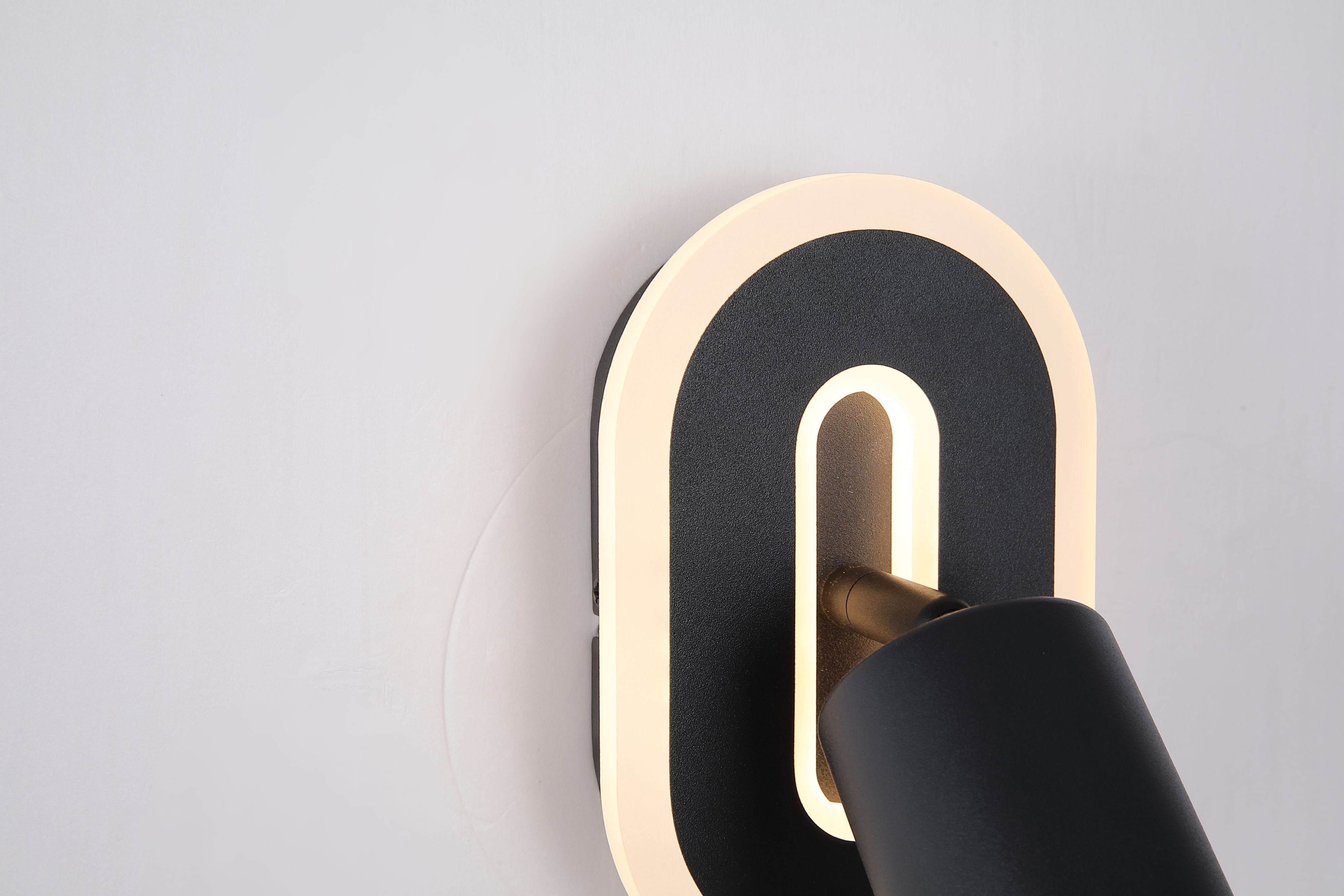 Close up angled view of the San Diego wall light in matt black, showing the arched LED halo and adjustable spotlight head