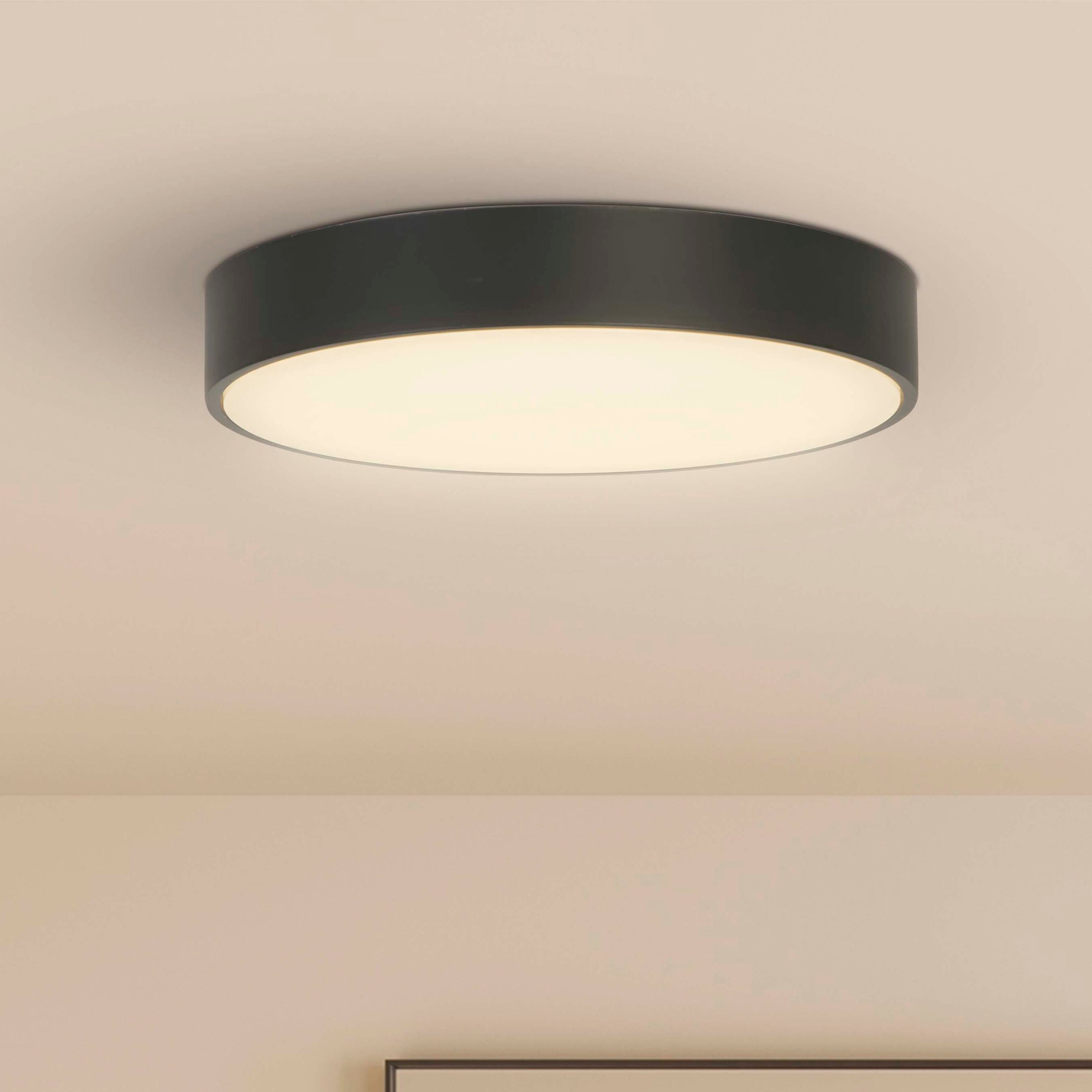 Searchlight Palma LED flush ceiling light installed on a ceiling above a framed abstract print in a pink toned room