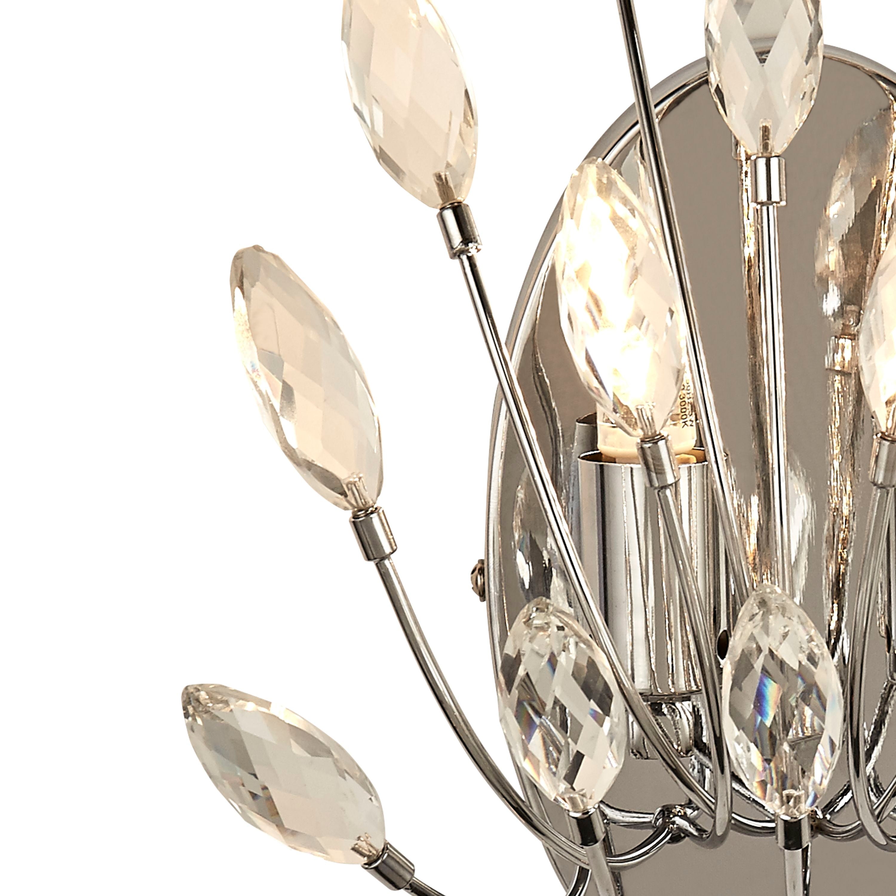 Close up of the Peacock wall light showing the lit candle bulb and faceted crystal leaves against the polished chrome backplate