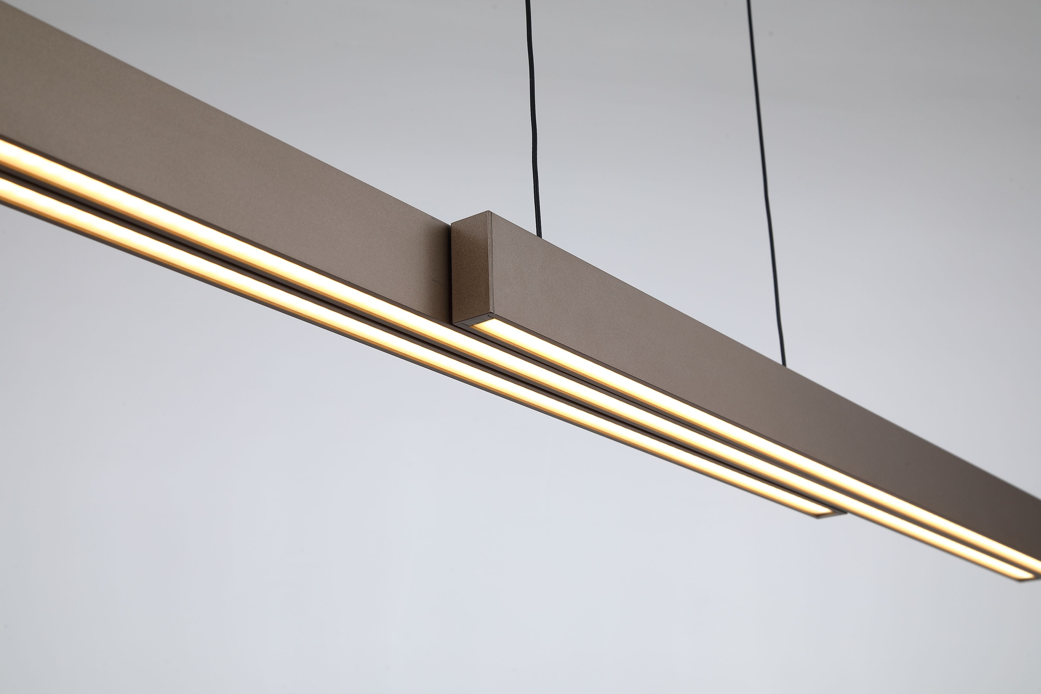 Close up of the Searchlight Linear LED pendant's latte aluminium frame, showing the panel join and the glowing frosted acrylic diffuser