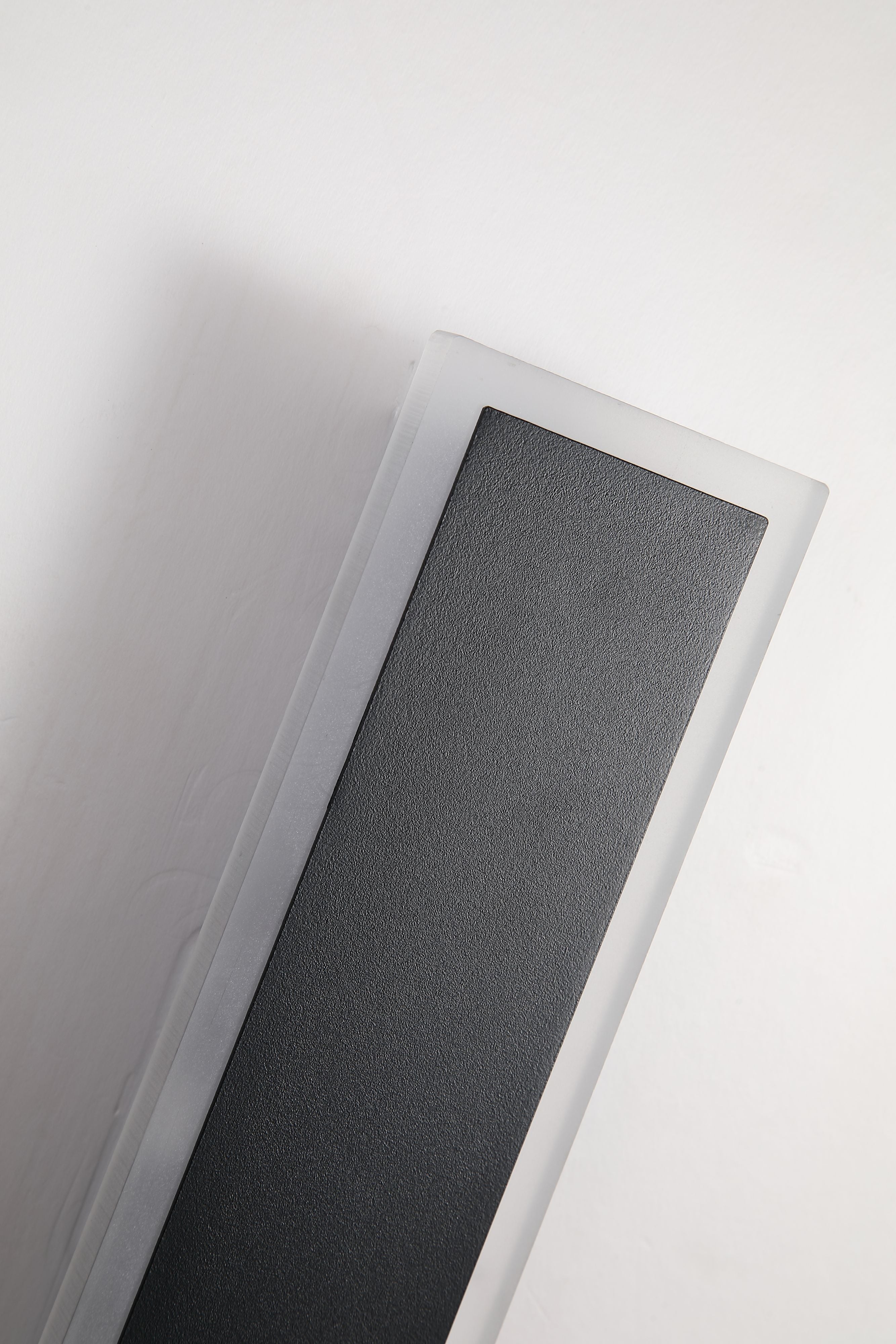Close up of the sand black textured finish and glowing acrylic edge on the Searchlight Bordo II Square LED Outdoor Wall Light, 300mm
