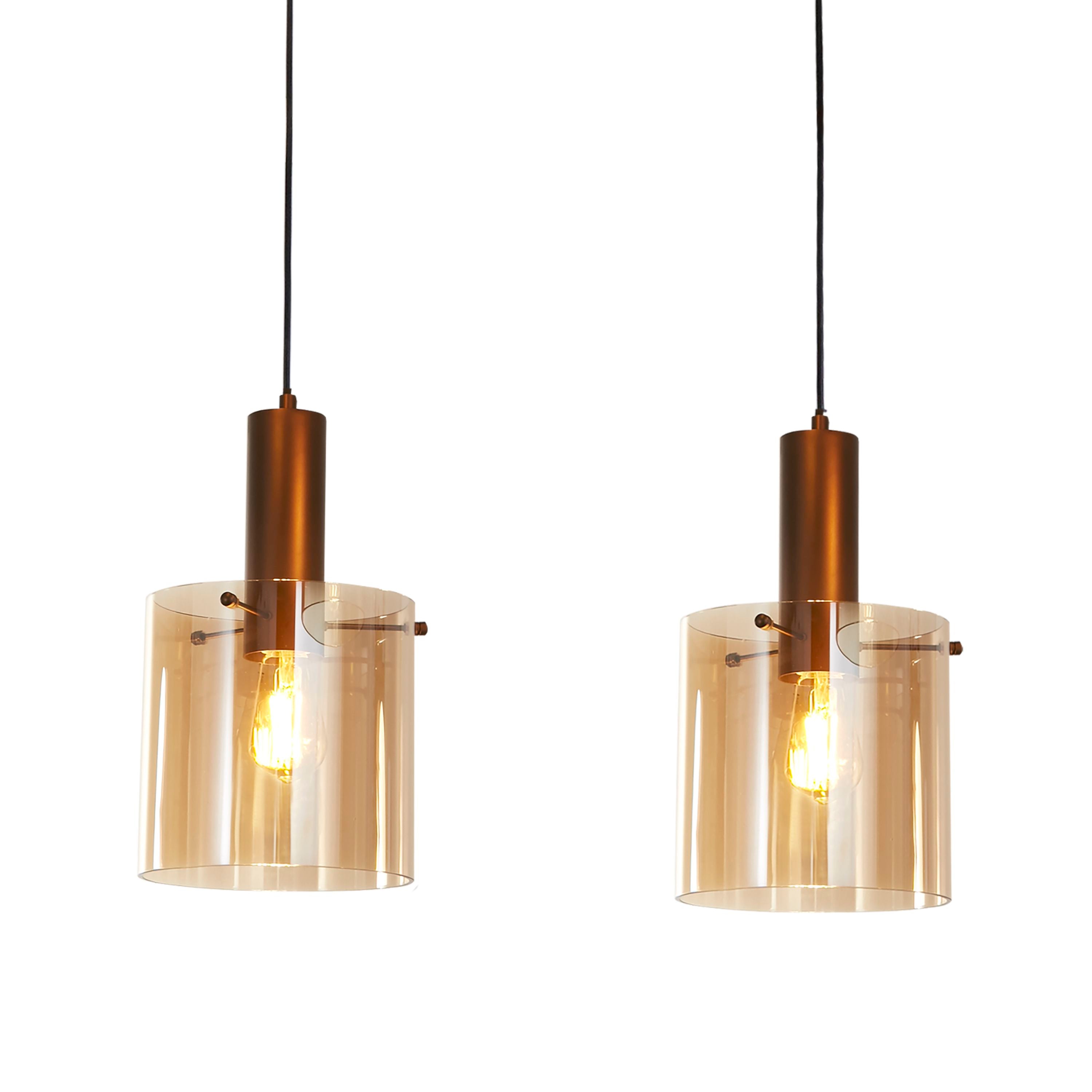 Close up of two Sweden 3 Light Bar Pendant shades in amber glass, showing the fade from amber to clear glass around the lit bulbs