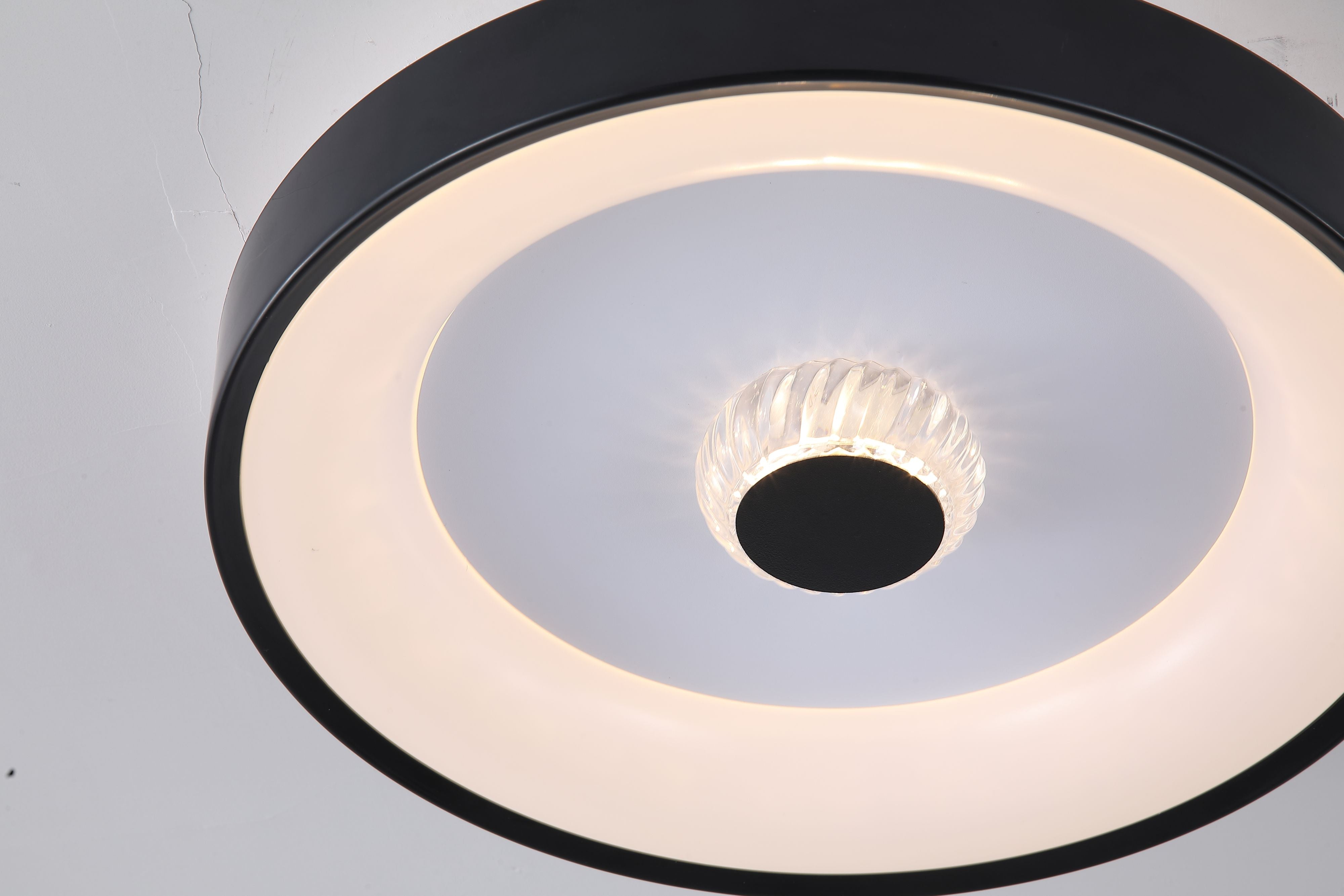 Close up detail of the Searchlight Polka LED Flush ceiling light showing the faceted crystal centre glowing warm white against the black centre boss and white ring diffuser