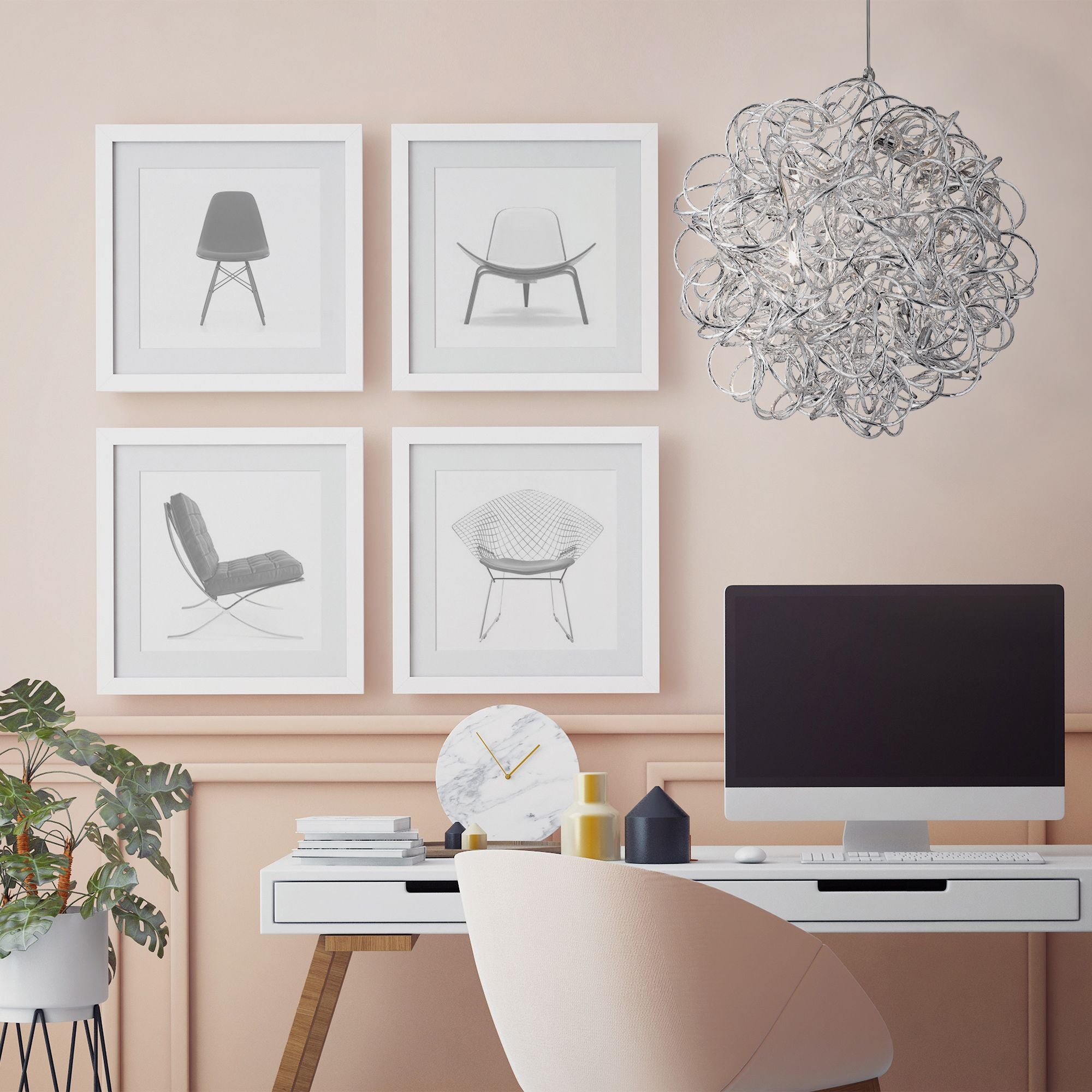 Scribble pendant hanging above a home office desk in front of a gallery wall of framed chair prints on a pink wall