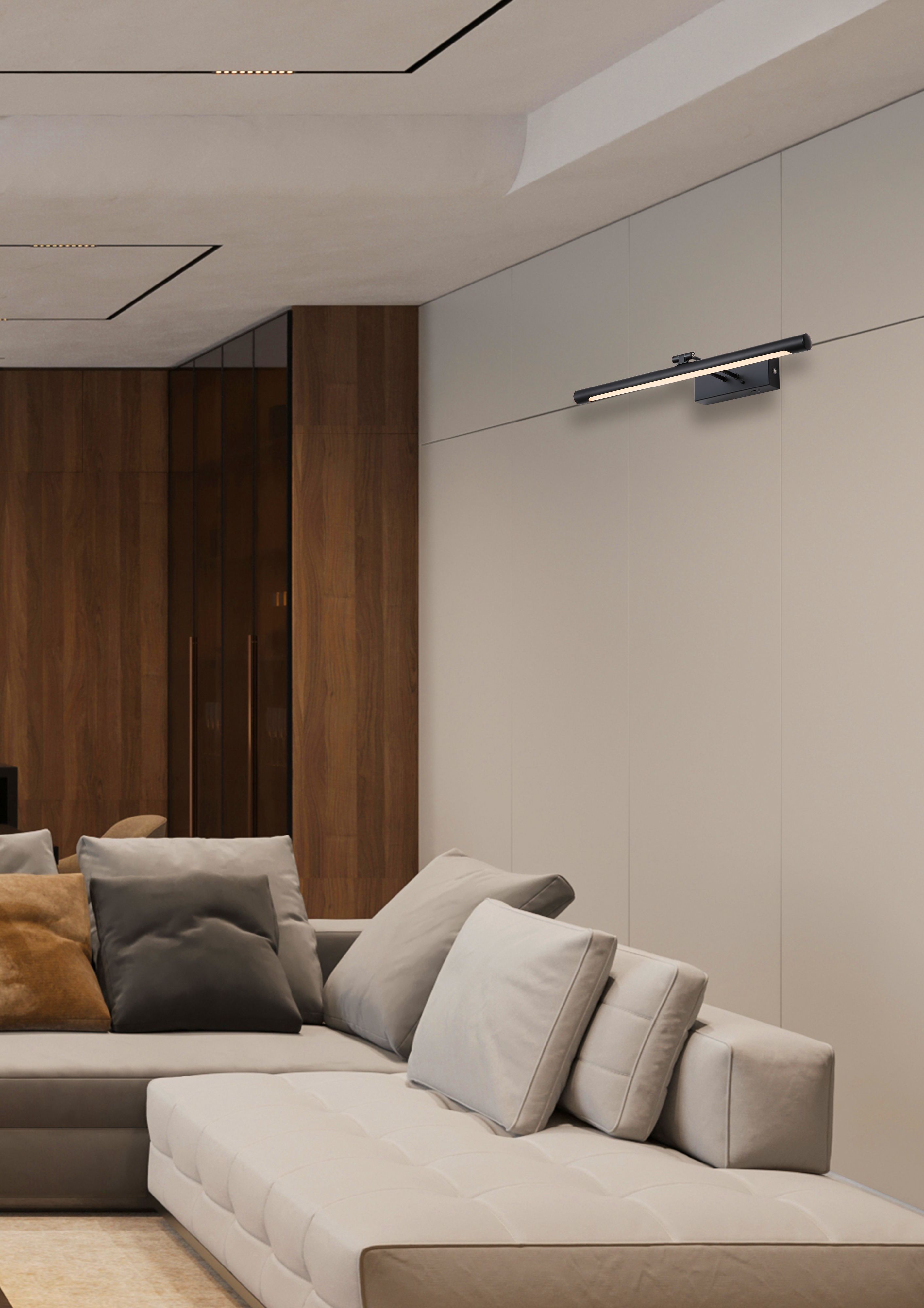 Holton matt black wall lamp mounted above a beige sofa on a panelled wall in a modern living room