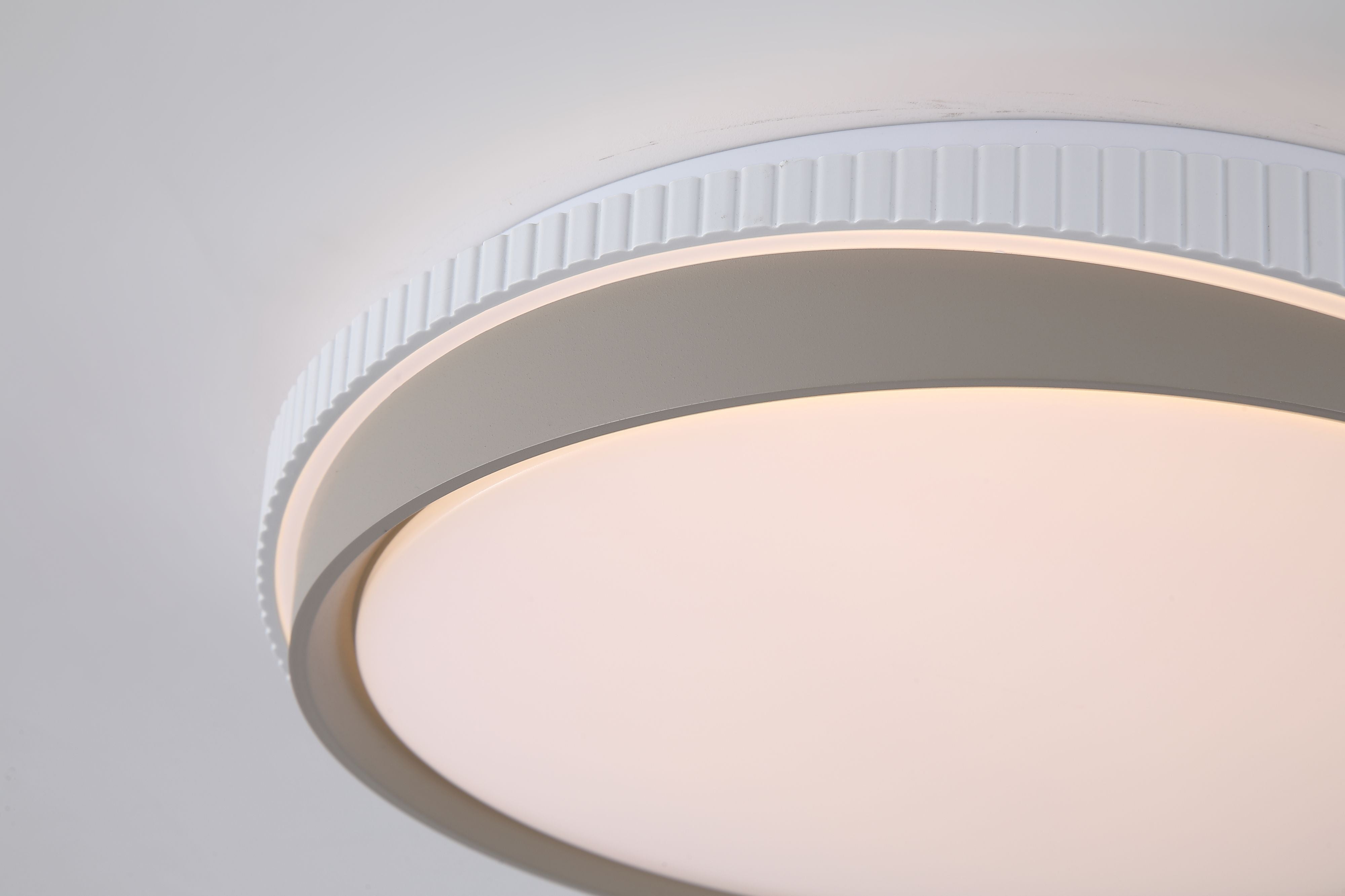 Close up of the Galactic Round 2 Tone flush ceiling light, showing the fluted white outer edge and gold inner ring in detail
