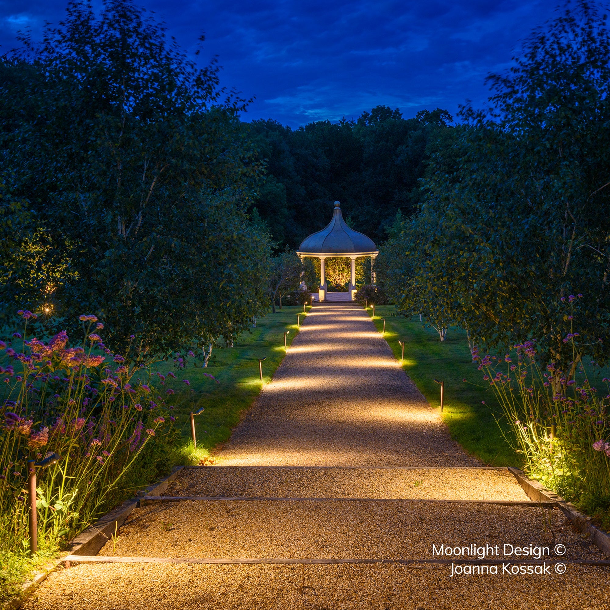 Avenue of Hunza Border Lights lighting a gravel path leading to a garden pavilion at dusk, Moonlight Design landscape lighting scheme