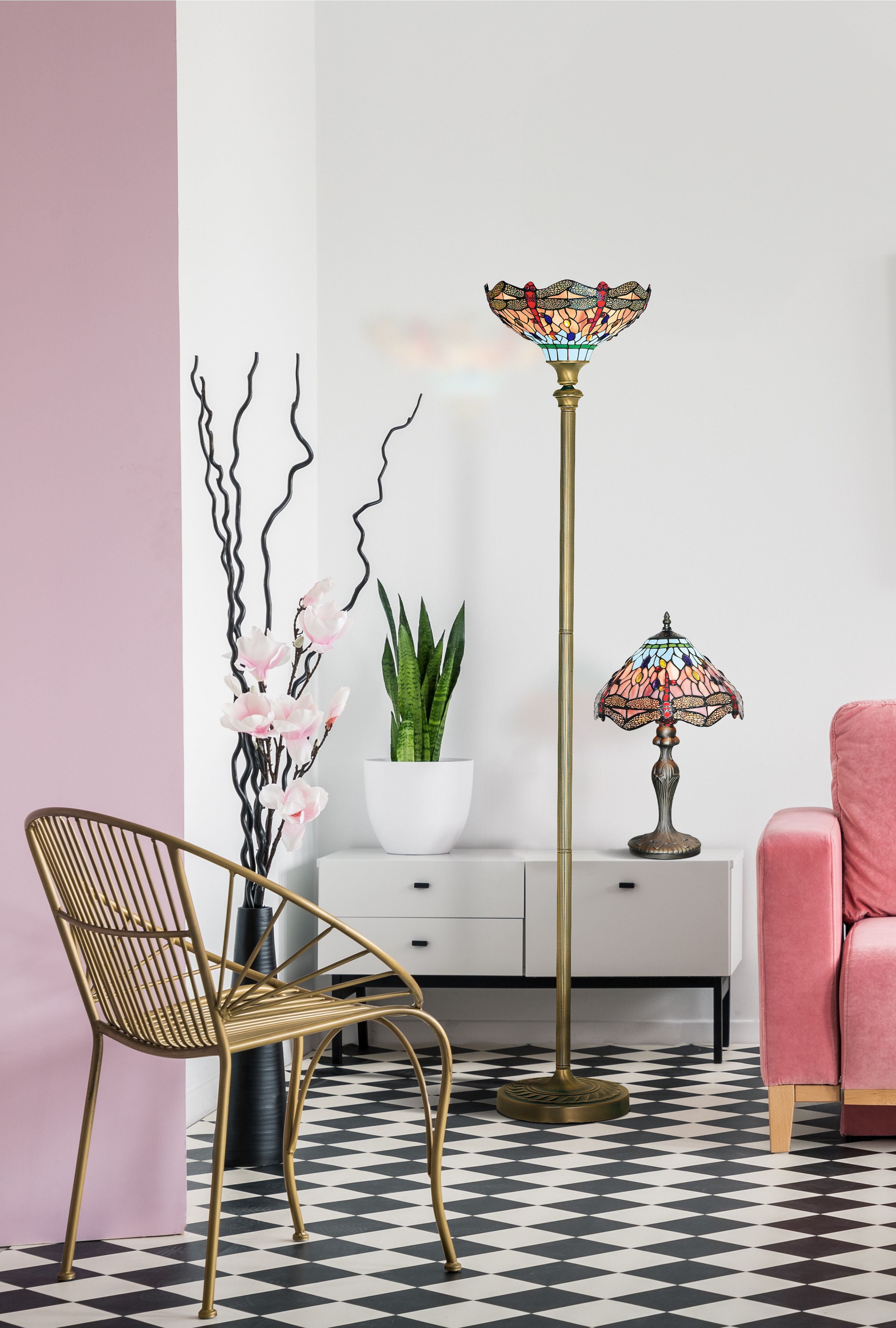 Dragonfly table lamp styled on a white sideboard next to the matching floor lamp, in a living room with a pink armchair