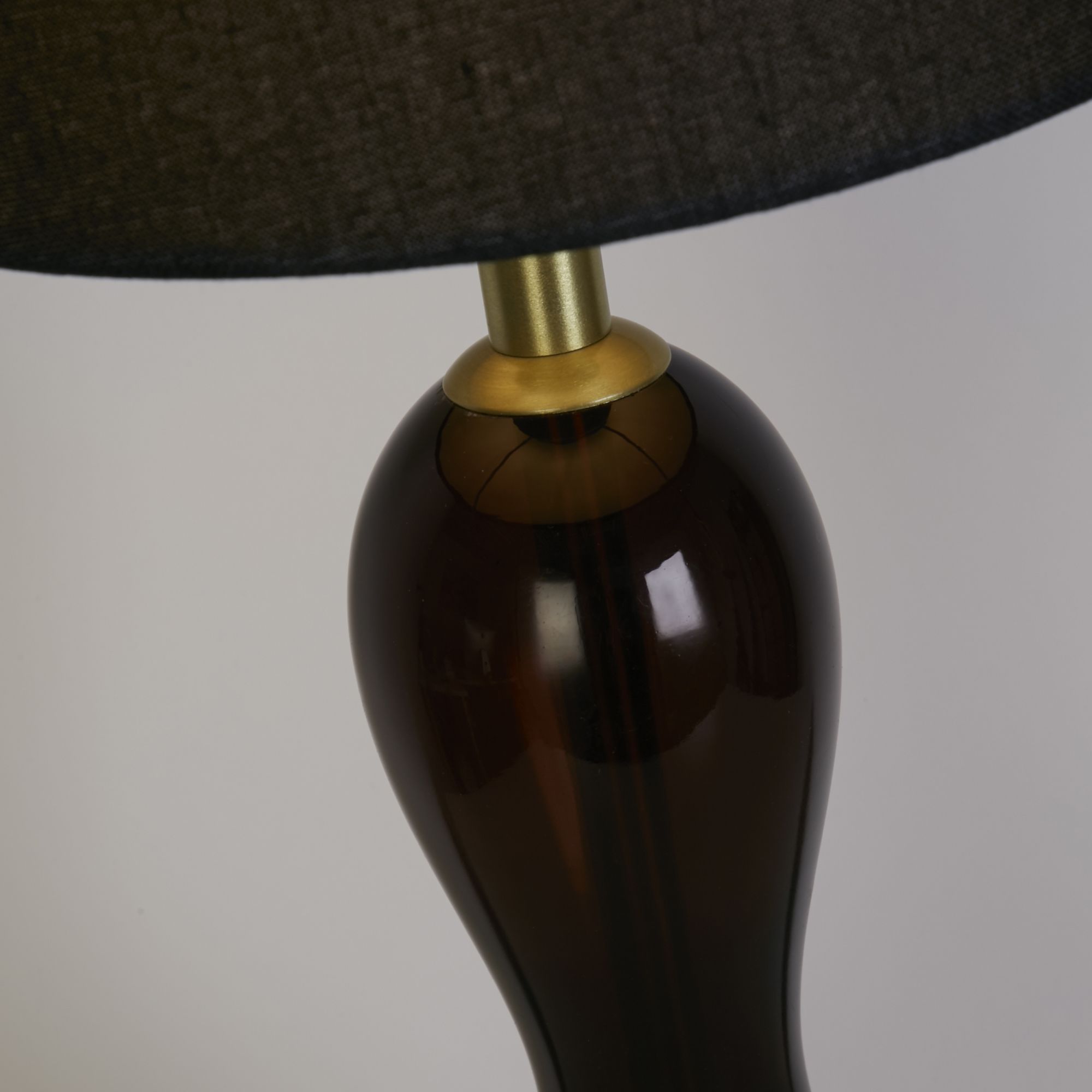 Close up of the Marakesh table lamp neck, showing the satin brass gallery fitting where the black ombre glass meets the shade