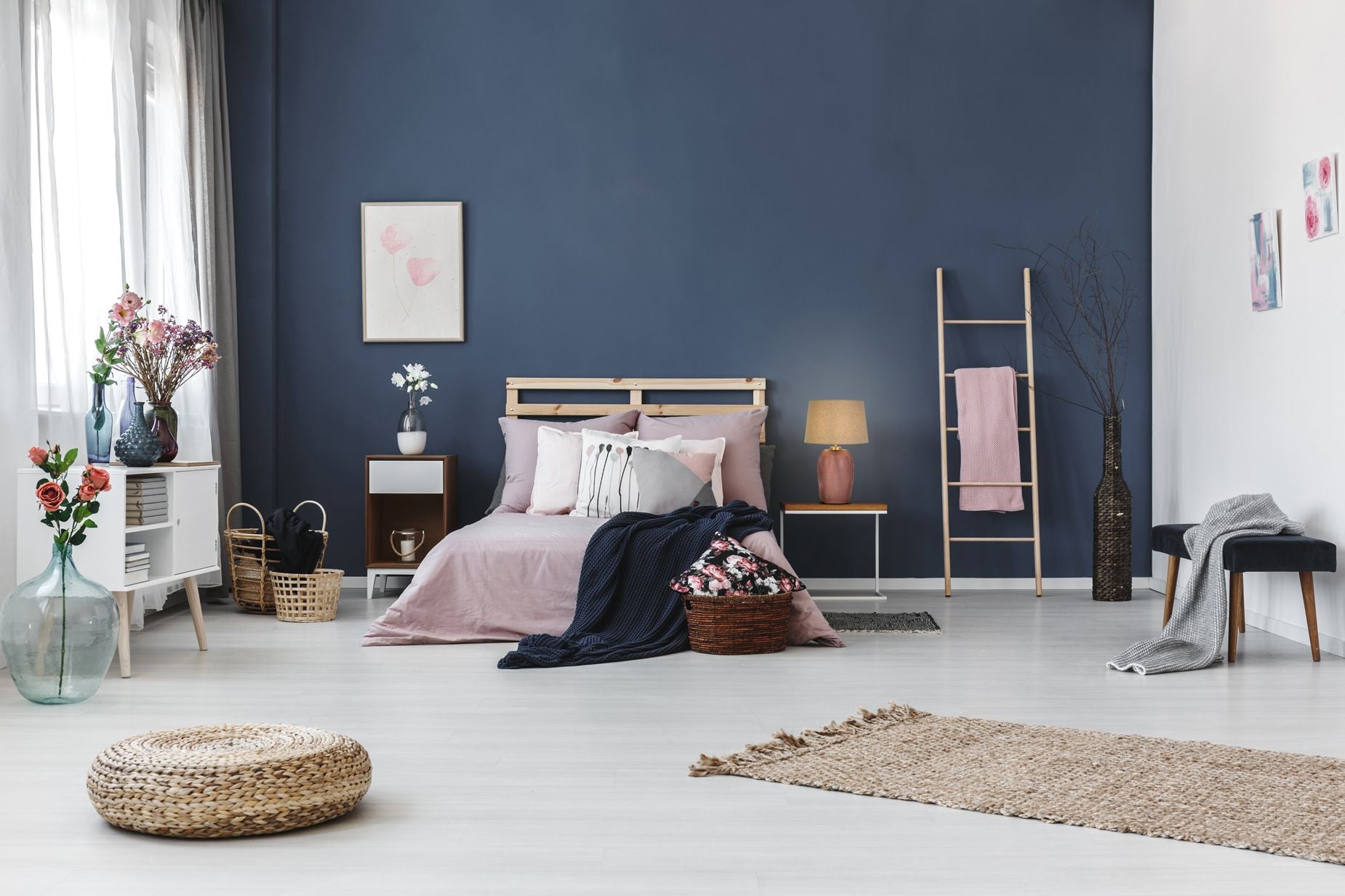 Amethyst pink glass table lamp styled on a bedside table against a navy wall with blush pink bedding