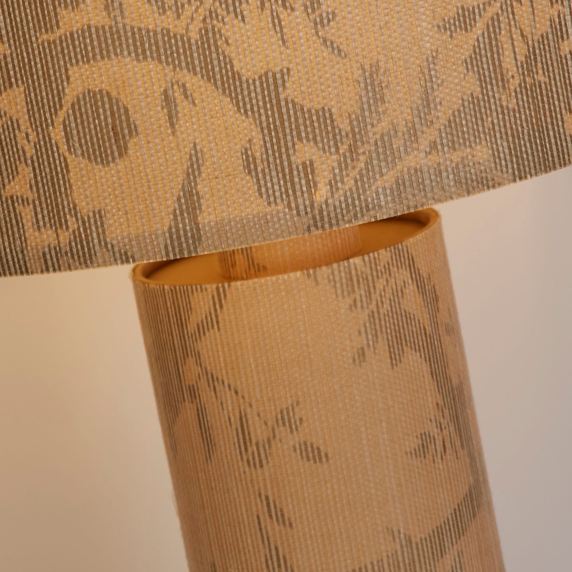 Close up of the join between the Isla Table Lamp's shade and ribbed base, showing the leaf print texture and paper construction in detail