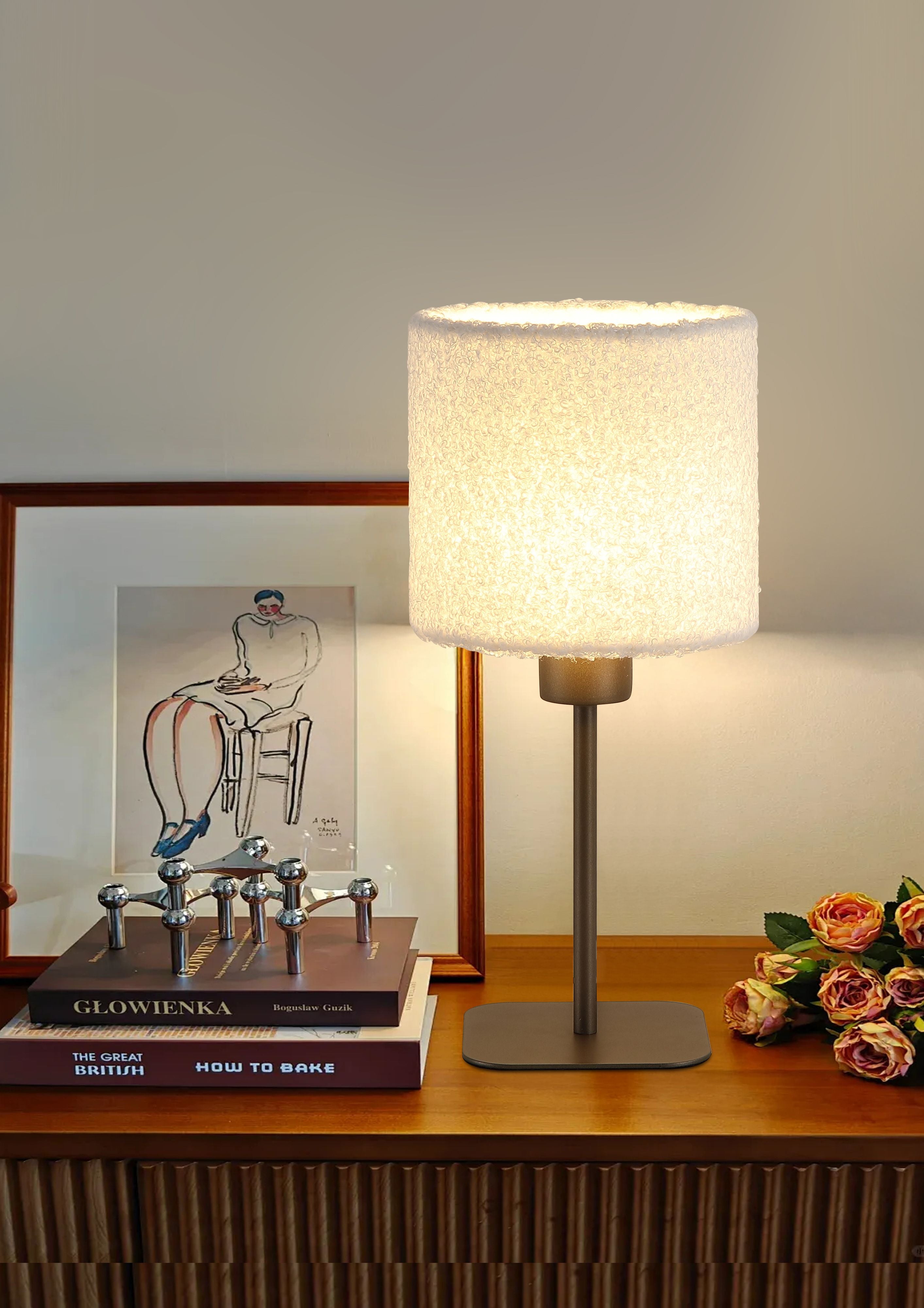 Searchlight Chelsea table lamp switched on beside a framed print and books on a wooden sideboard in a styled room