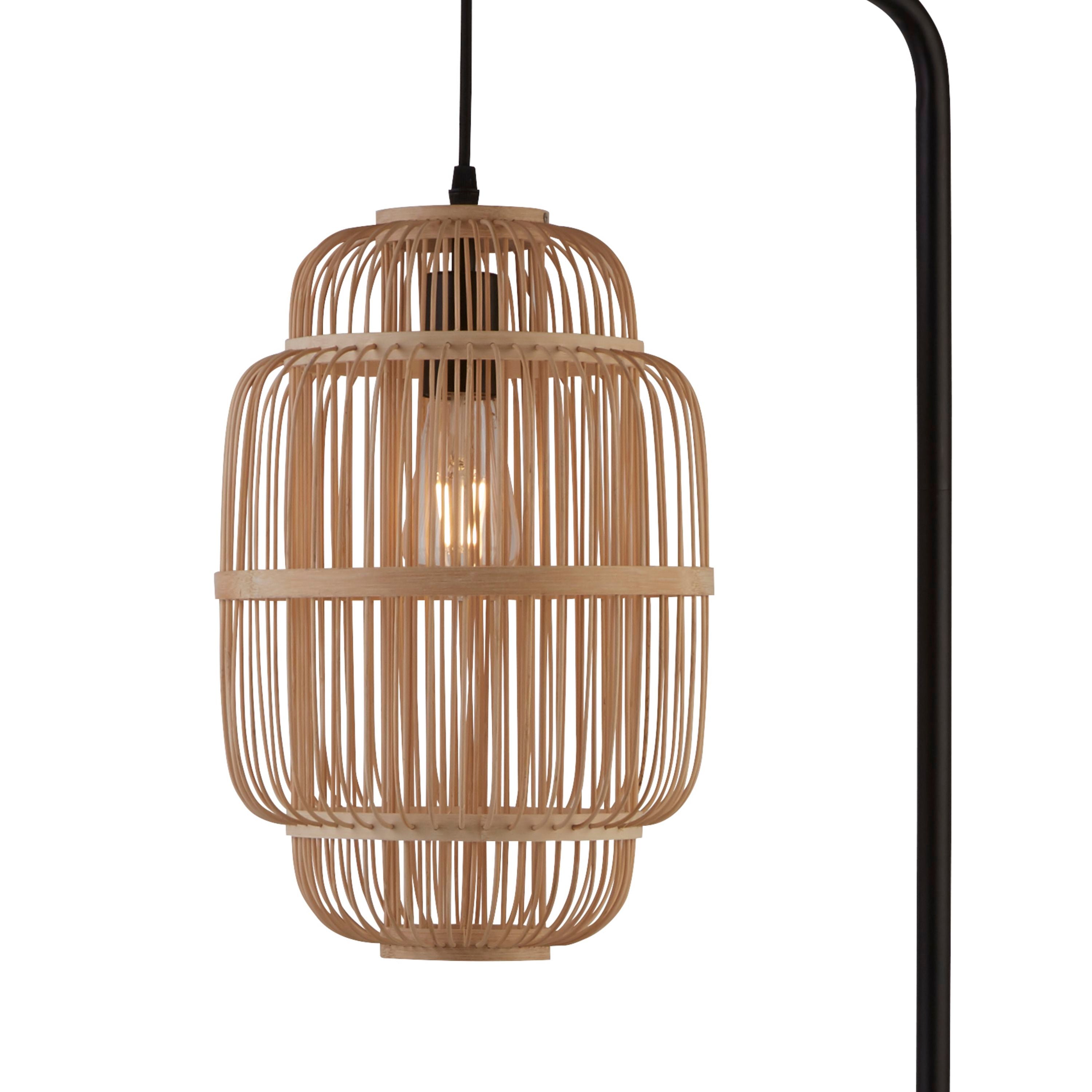 Close up of the Java floor lamp's woven bamboo cage shade with the filament bulb glowing inside