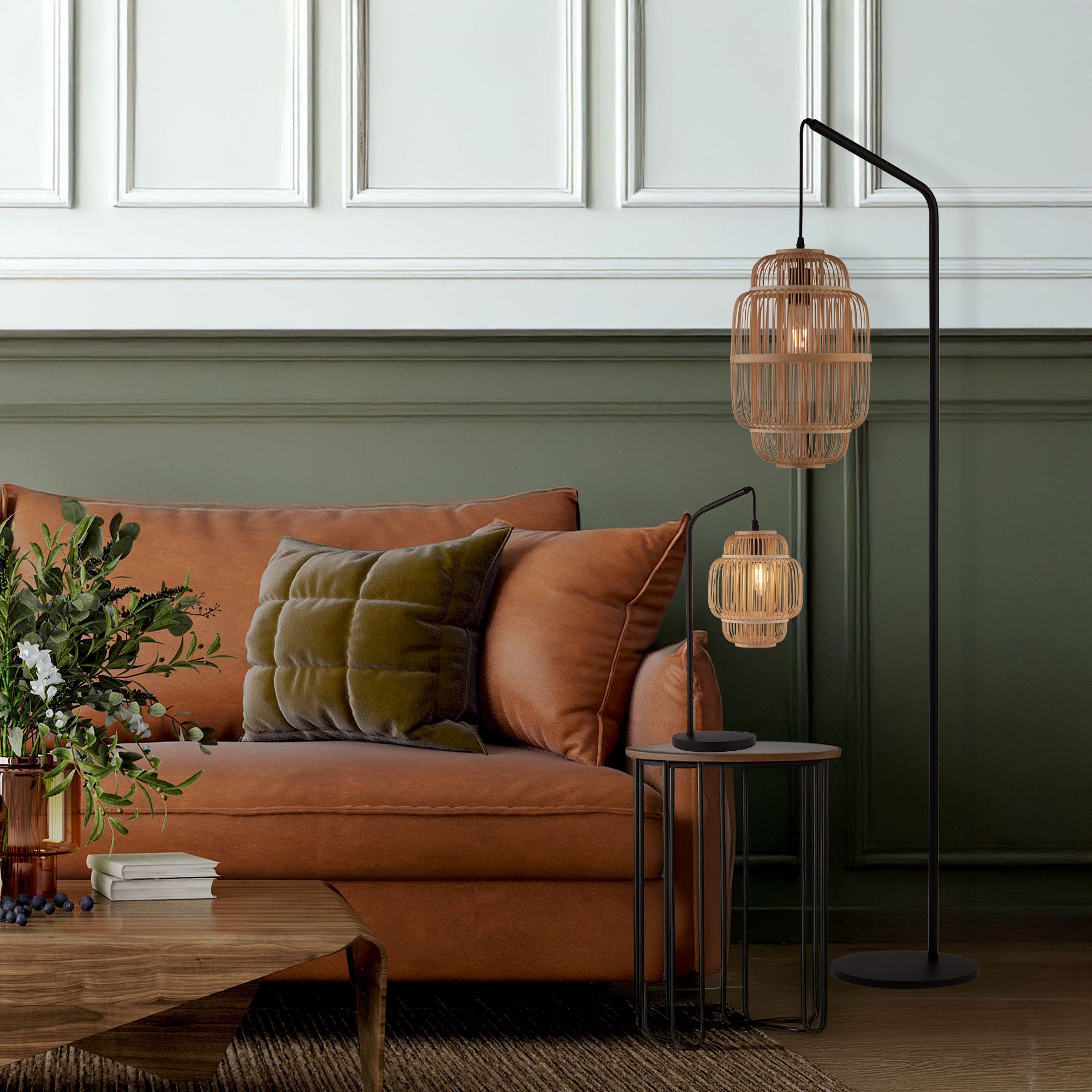 Java floor lamp styled in a green panelled living room beside a tan leather sofa, next to the matching Java table lamp