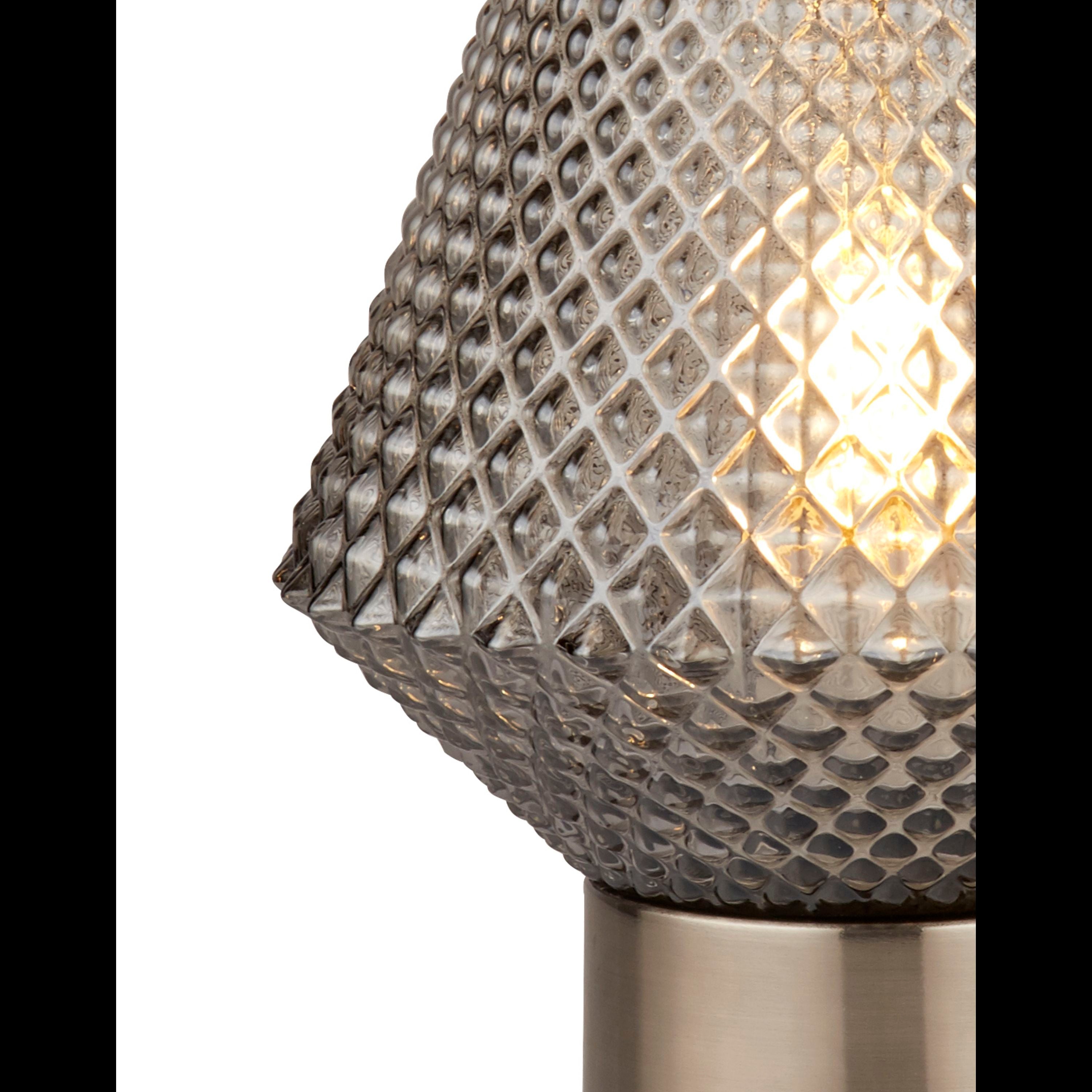 Close up of the Searchlight Avia table lamp showing the raised diamond texture of the smoked glass shade and the lit bulb inside