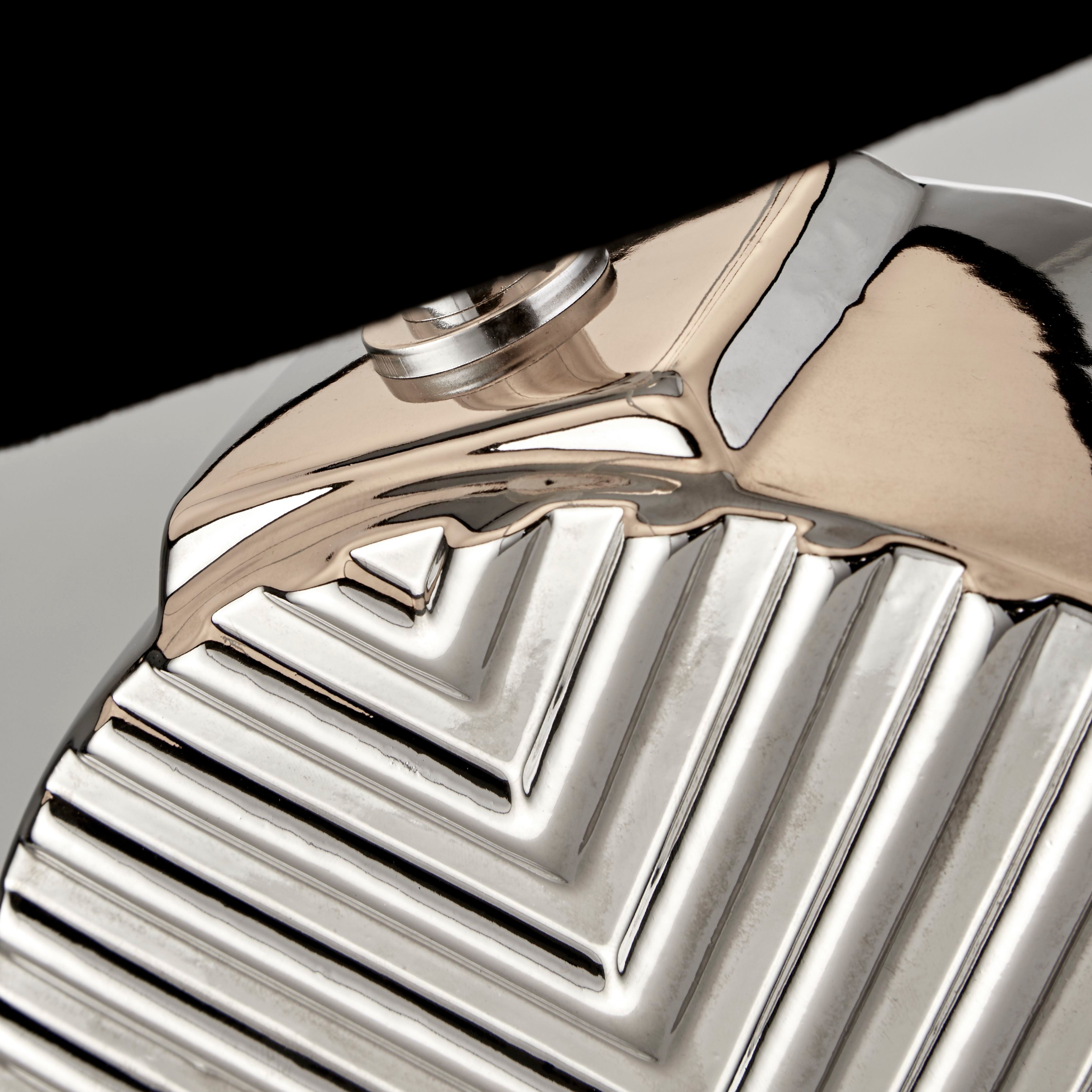 Close up of the Regen lamp's chevron textured chrome finish and polished edge detail