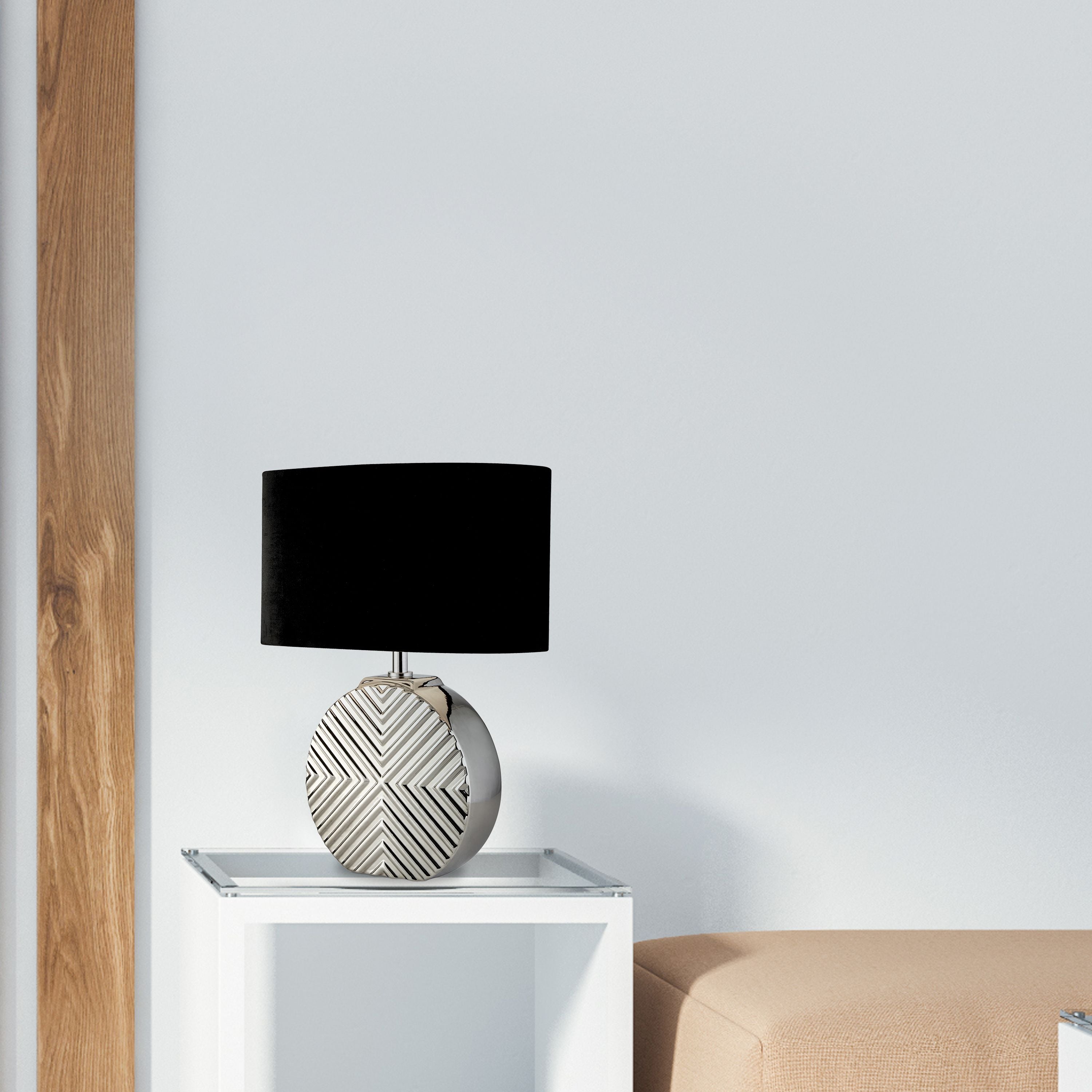 Regen table lamp styled on a white glass side table beside a beige sofa