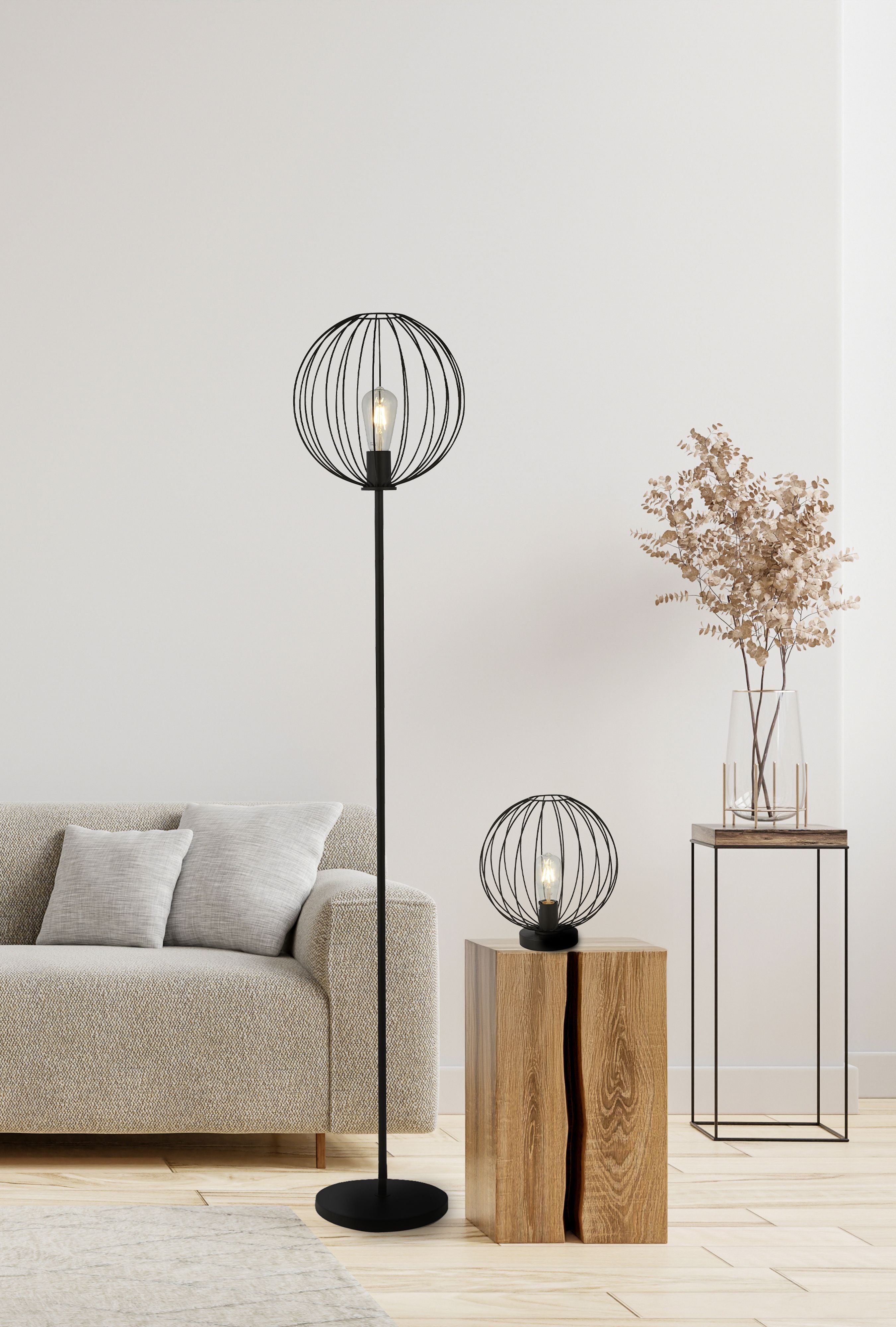 Rondo floor lamp styled in a living room beside a beige sofa, with a matching black wire table lamp on a wooden side table