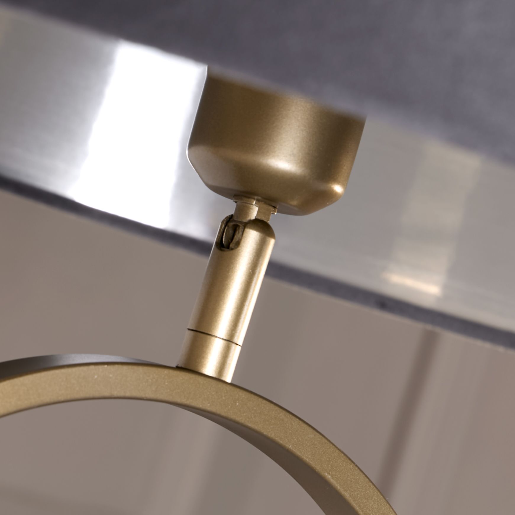 Close up of the bronze oval frame and adjustable fitting where the dark grey velvet shade attaches
